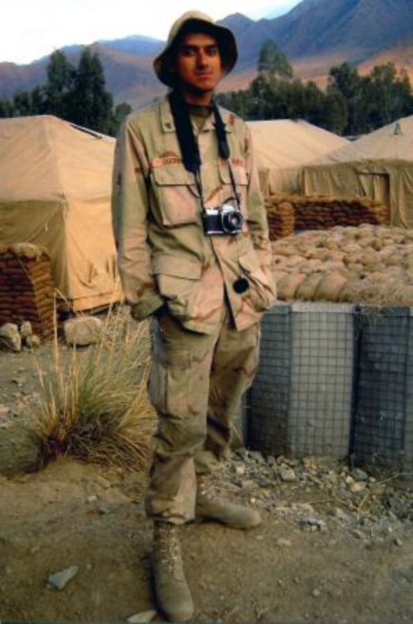 Carlos Guerra, prior mortarman in the Marine Corps and current photographer on Marine Corps Logistics Base Barstow, Calif., poses in Afghanistan with his camera during a deployment. Guerra brought his camera with him on every deployment.


