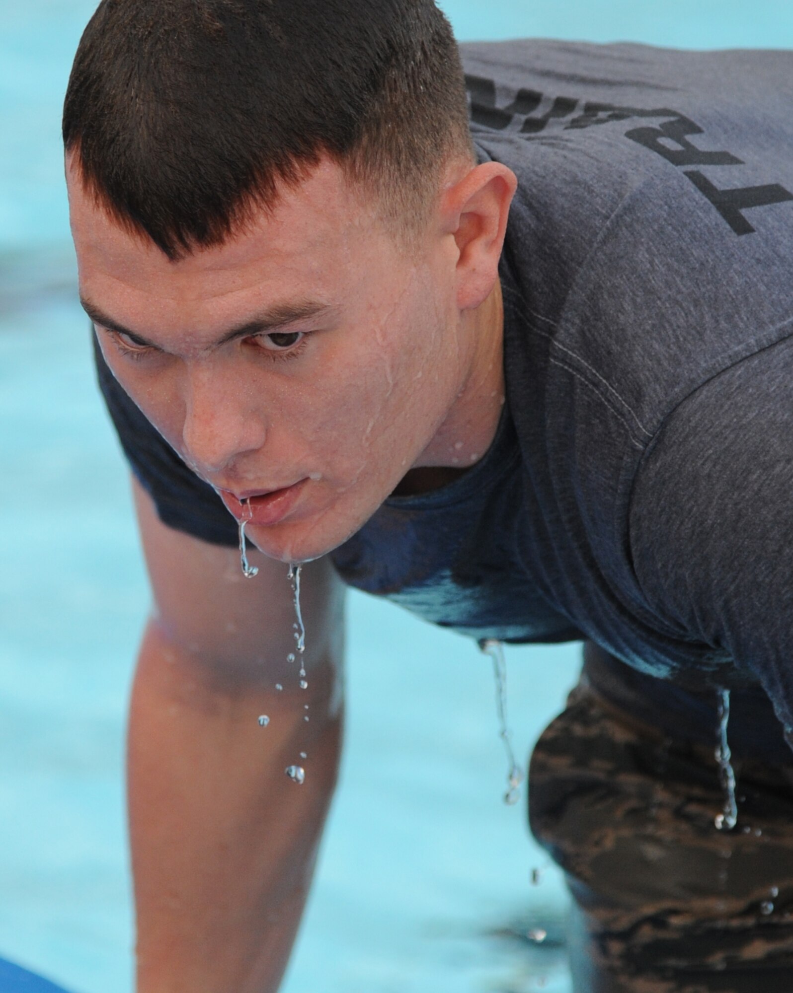 Airman 1st Class James Tarbutton, 334th Training Squadron combat controller student, exits the Triangle pool after swimming freestyle laps during a memorial physical training session with members of the 334th Training Squadron combat controllers and the 335th Training Squadron special operations weather team Sept. 27, 2013, at Keesler Air Force Base, Miss.  The PT event was in memory of combat controller Senior Airman Mark Forester who was killed in action on Sept. 29, 2010. (U.S. Air Force photo by Kemberly Groue)
