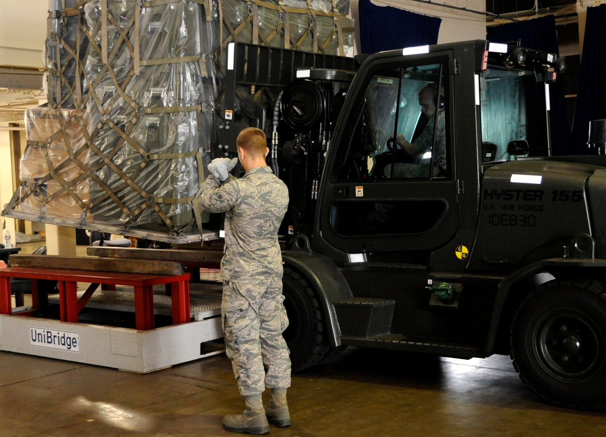 Airman 1st Class Charles Burkhardt, 35th Civil Engineer Squadron water and fuels maintenance journeyman, left, guides Senior Airman Devon Watts, 35th Maintenance Squadron aerospace propulsion journeyman, as he lowers a pallet onto a scale during an Operational Readiness Exercise at Misawa Air Base, Japan, Oct. 2, 2013. An ORE tests a base’s ability to deploy personnel, equipment and support assets to a combat environment during a crisis. (U.S. Air Force photo by Airman 1st Class Kaleb Snay)
