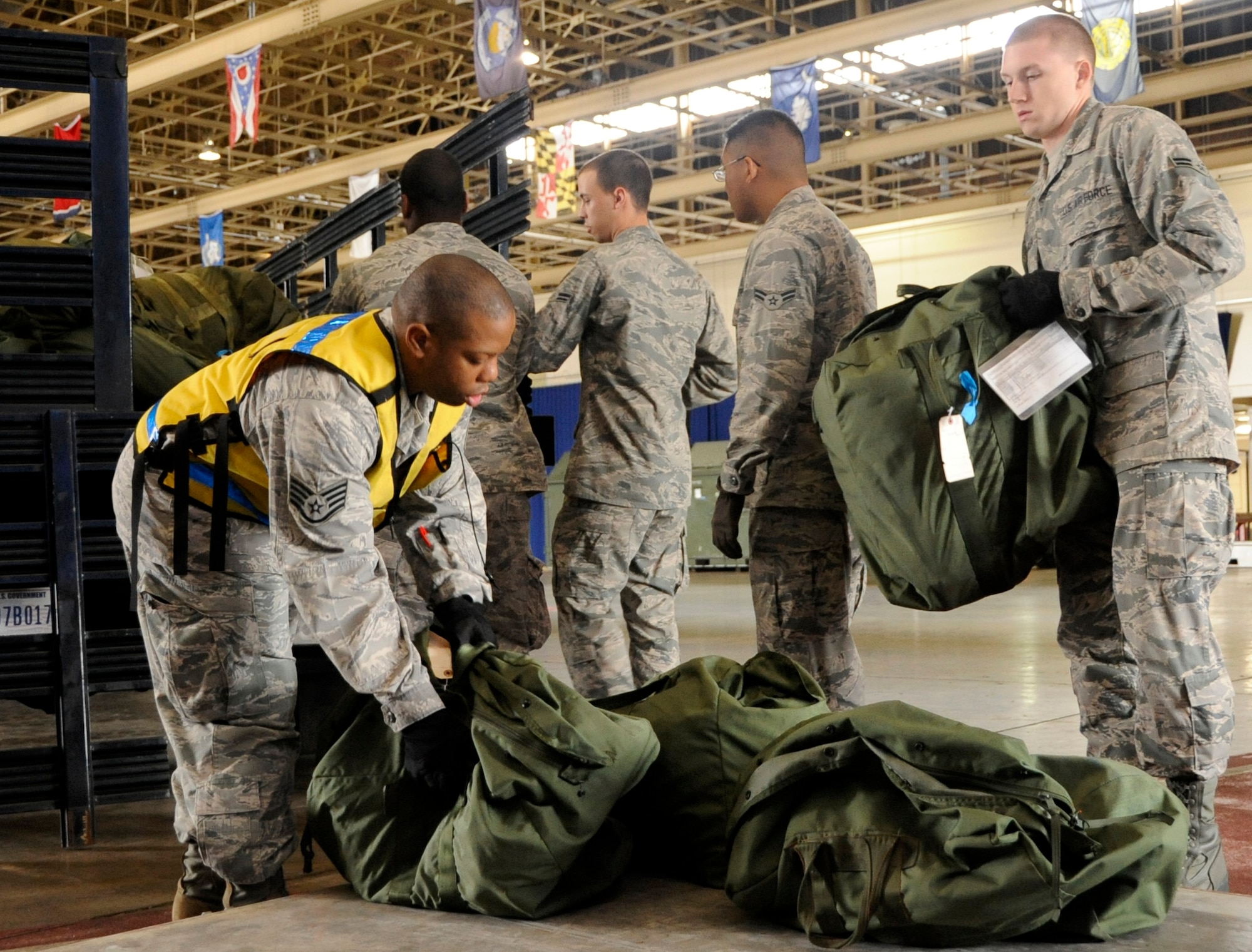 Airmen working on a Pallet Team unload and stack chemical gear bags during an Operational Readiness Exercise at Misawa Air Base, Japan, Oct. 2, 2013. Airmen go through a Personnel Deployment Function line during a simulated deployment, where their bags must be palletized for transportation. (U.S. Air Force photo by Airman 1st Class Kaleb Snay)