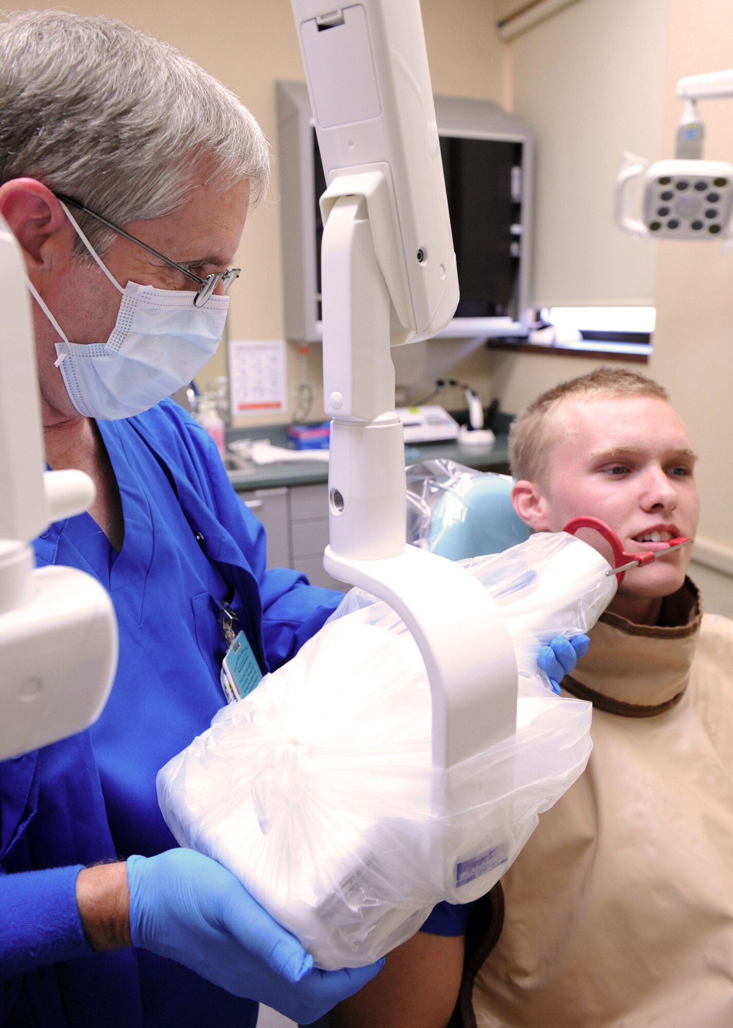 Steven Harris, 7th Aerospace Medical Squadron dental assistant, takes X-rays of Airman 1st Class Evan Wolfe , 7th AMDS, Sept. 26, 2013, at the 7th Medical Group on Dyess Air Force Base, Texas.  The 7th AMDS uses X-rays to assess a patient’s dental health. (U.S. Air Force photo by Airman 1st Class Kedesha Pennant/Released)