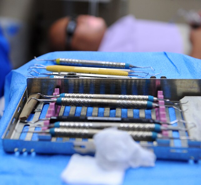 A set of dental tools lies to the side of Tech Sgt. Marc Larion, 7th Maintenance Group, to be used for his dental cleaning, Sept. 26, 2013, at the 7th Medical Group on Dyess Air Force Base, Texas.  These tools are kept in sterile conditions until they’re utilized and are re-sterilized daily to make sure Airmen receive the best of care. (U.S. Air Force photo by Airman 1st Class Kedesha Pennant/Released)