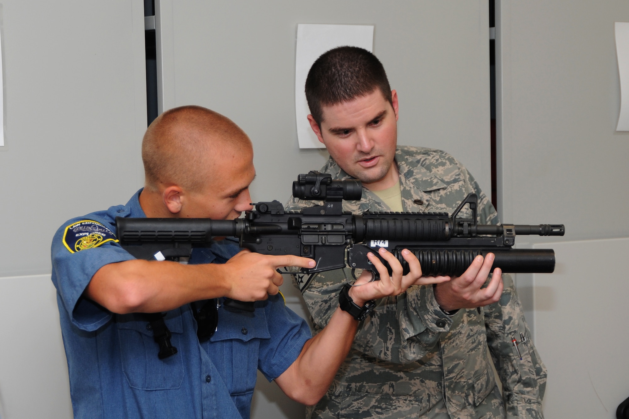 Staff Sgt. Derek Fox, 375th Security Forces NCOIC of Armory shows an explorer how to properly hold the weapon at the Security Forces Armory Sept. 25, 2013. The explorer program is available in many towns across the country to help young adults decide whether this is a good career for them. (U.S. Air Force photo/Airman Megan Friedl)
