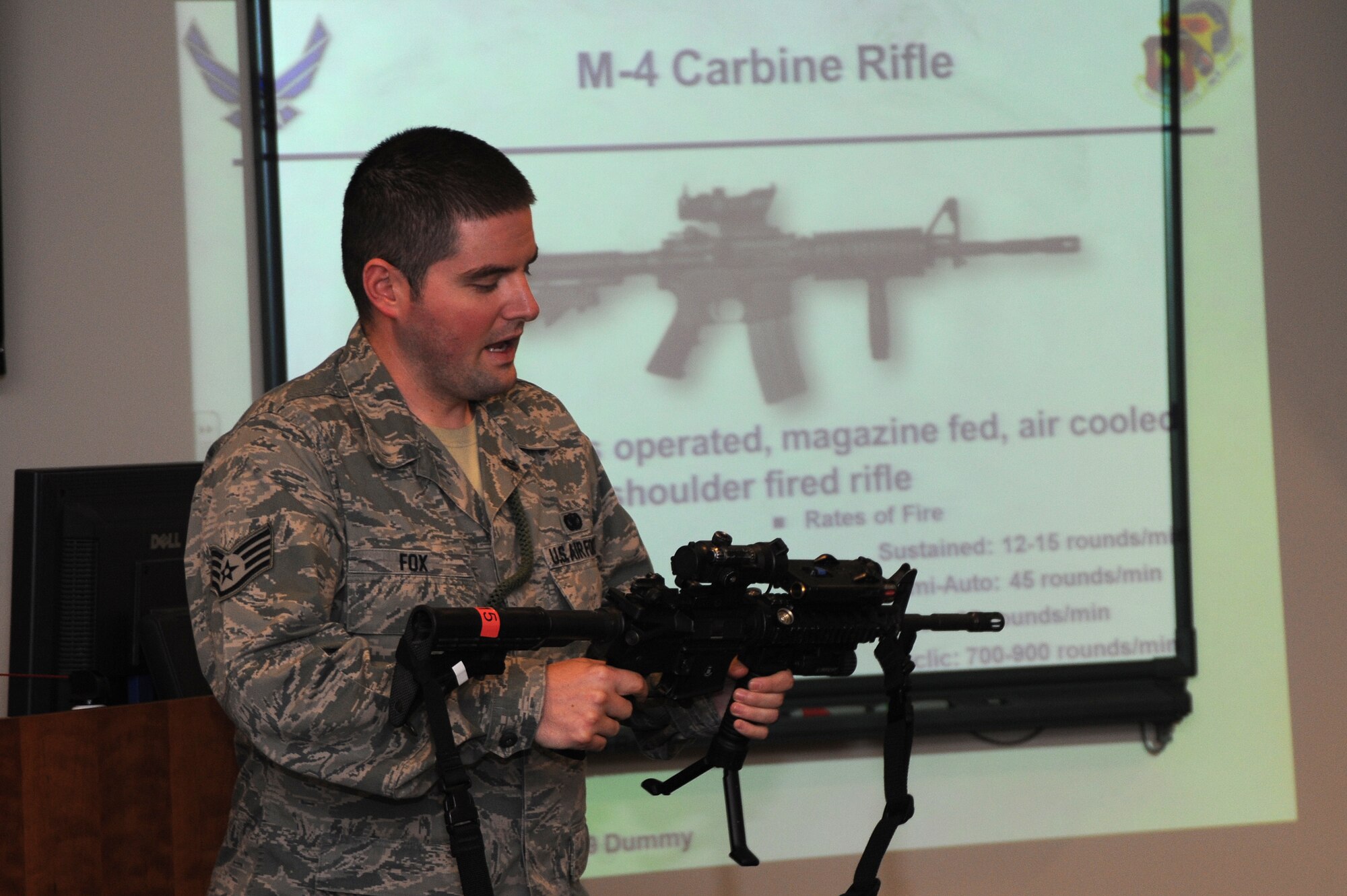 Staff Sgt. Derek Fox, 375th Security Forces NCOIC of Armory holds an M-4 Carbine Rifle and describes the capabilities and details of the weapon for the Law Enforcement explorers at the Security Forces building Sept. 25, 2013. Fox also described his job duties in the armory and the various weapons he takes care of. (U.S. Air Force photo/Airman Megan Friedl)