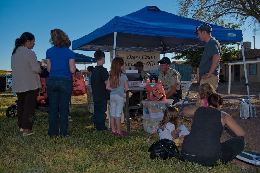 Members of Team Holloman and Alamogordo residents speak with Otero County sheriffs at the National Night Out event hosted by Soaring Heights Communities at Holloman Air Force Base, N.M., Oct 1. The Otero County Sheriffs Department, Alamogordo Department of Public Safety and the 49th Security Forces Squadron Community Police attended the event to showcase their support in the fight for a safer community. (U.S. Air Force photo by Airman 1st Class Aaron Montoya/Released)