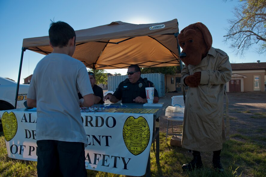 A Team Holloman dependent listens to safety tips from the Alamogordo Department of Public Safety at the annual National Night Out event hosted by Soaring Heights Communities at Holloman Air Force Base, N.M., Oct 1. The Otero County Sheriffs Department, Alamogordo Department of Public Safety and the 49th Security Forces Squadron Community Police attended the event to showcase their support in the fight for a safer community. (U.S. Air Force photo by Airman 1st Class Aaron Montoya/Released)
