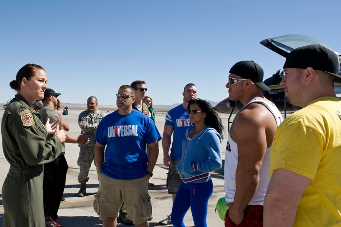 Capt Audry Shontz, 64th Aggressor Squadron baron controller, tells Universal Nutrition sponsored athletes about the mission of the 64th AGRS Sept. 26, 2013, at Nellis Air Force Base, Nev. Universal Nutrition sponsored athletes visited Nellis AFB before attending the 2013 Olympia Competition and Expo Weekend Sept. 26-29 at the Las Vegas Convention Center. The athletes hosted a meet and greet at the Exchange where they gave fitness pointer, signed autographs and took photos with Airmen. (U.S. Air Force photo by Senior Airman Matthew Lancaster)