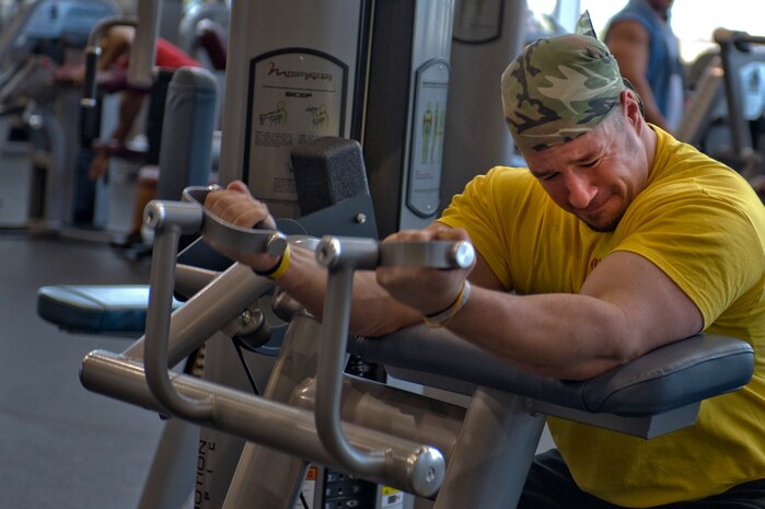 Greg Santarsiero, Universal Nutrition marketing manager, uses a bicep machine at the Warrior Fitness Center Sept. 26, 2013, at Nellis Air Force Base, Nev. The athletes did a meet and greet at the Exchange where they gave fitness pointers, signed autographs and took photos with Airmen. (U.S. Air Force photo by Senior Airman Matthew Lancaster)