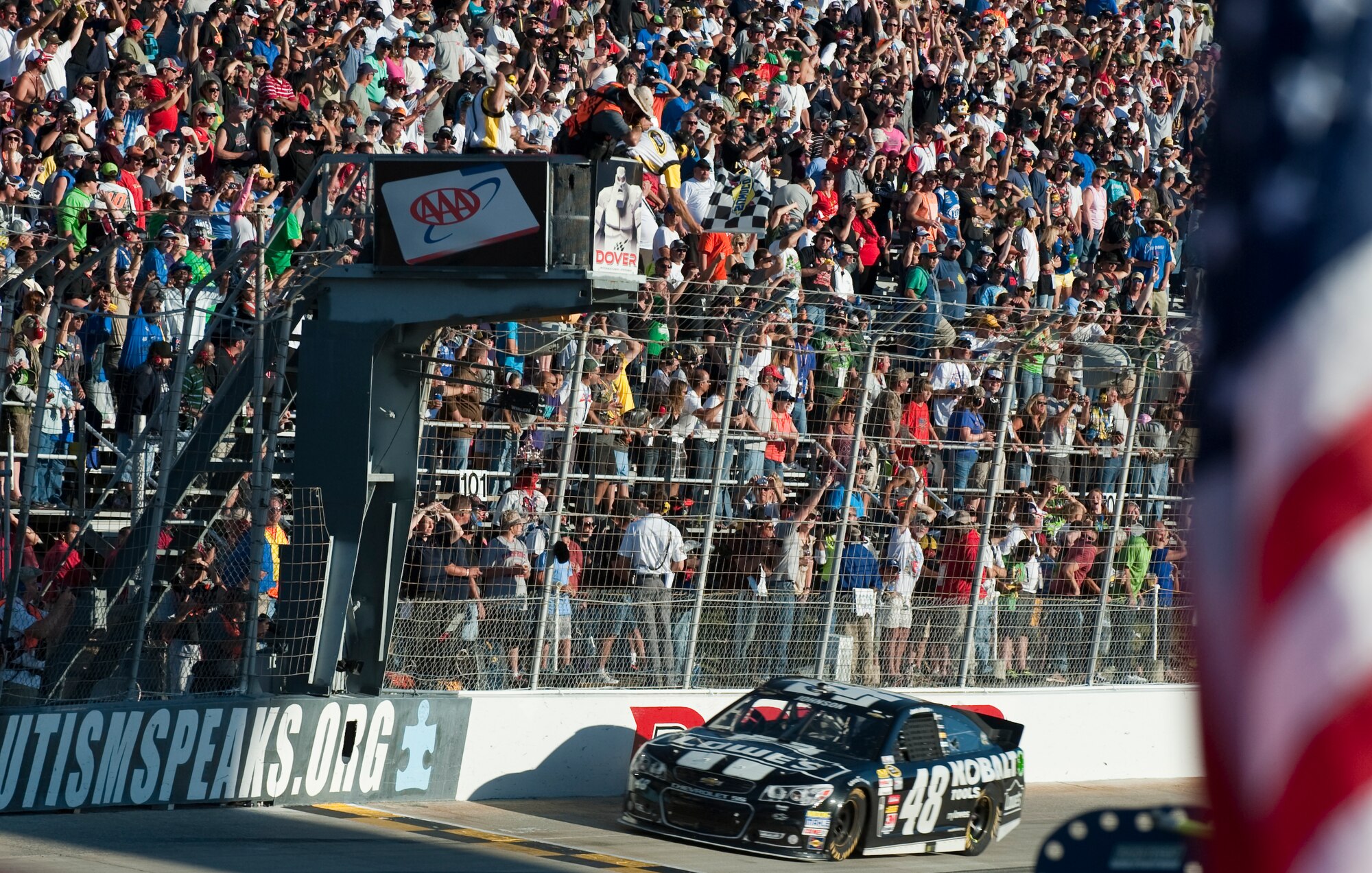 Jimmie Johnson, driver of the No. 48 Kobalt Chevy, crosses the finish line as the flagman waves the checkered flag at the AAA 400 Sept. 29, 2013, at Dover International Speedway in Dover, Del. Johnson won at Dover for a record-breaking eighth time. (U.S. Air Force photo/Senior Airman Jared Duhon)