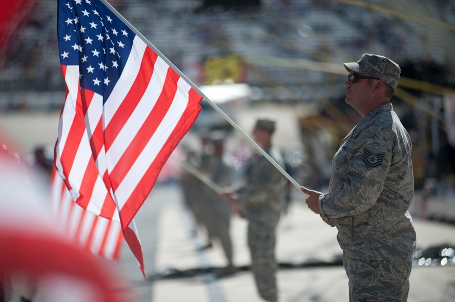 Tech. Sgt. Steve Porell, Delaware Air National Guard 166th Logistics Readiness Squadron, holds the U.S. flag during the pre-race ceremonies before the start of the AAA 400 Sept. 29, 2013, at Dover International Speedway in Dover, Del. The Delaware National Guard participated in a variety of activities in support of race weekend. (U.S. Air Force photo/Senior Airman Jared Duhon)