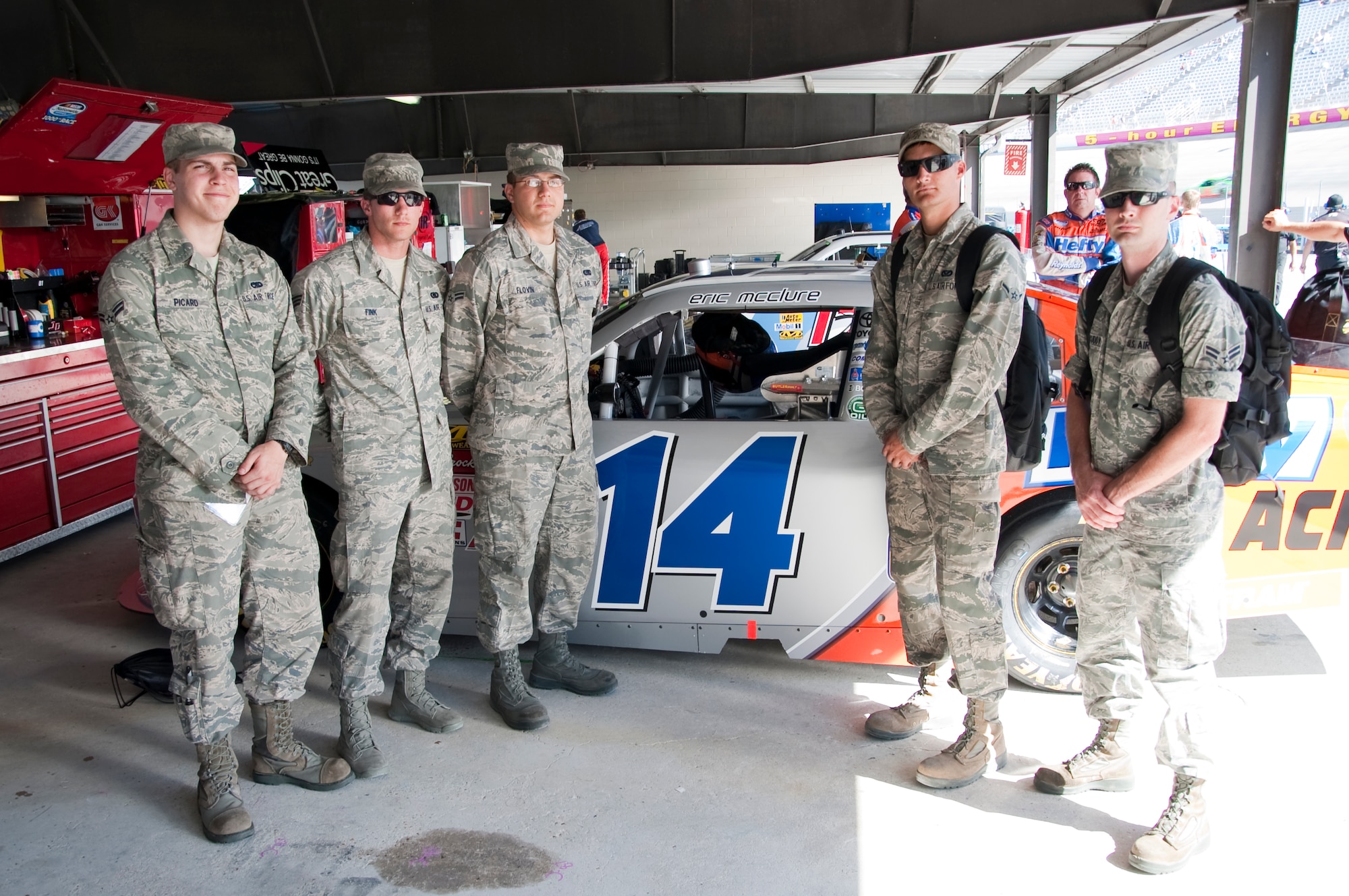 Team Dover Airmen stand in front of Eric McClure’s No. 14 Hefty Chevy in the garage area Sept. 28, 2013, at Dover International Speedway in Dover, Del. The Airmen served as honorary pit crew members for McClure and were able to spend time with his pit crew and watch the race from his pit box. (U.S. Air Force photo/Senior Airman Jared Duhon)