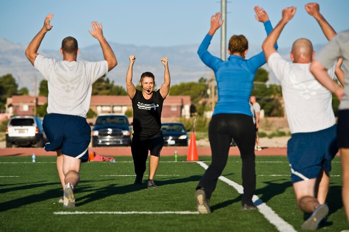 Missy Cornish, wife of Col. Barry Cornish, 99th Air Base Wing commander, leads a warrior trained fitness workout on the field at the track behind the Warrior Fitness Center Sept. 26, 2013, at Nellis Air Force Base, Nev. The warrior trained fitness, high intensity interval training promotes the “Life of a Warrior” idea. The “Life of a Warrior” concept is about living a healthier lifestyle. (U.S. Air Force photo by Airman 1st Class Christopher Tam)