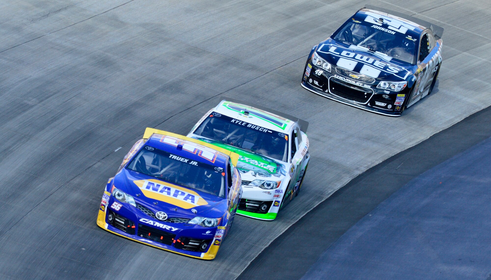 Martin Truex, Jr., driver of the No. 56 NAPA Auto Parts Toyota, Kyle Busch, driver of the No. 18 Interstate Batteries Toyota, and Jimmie Johson, driver of the No. 48 Kobalt/Lowe’s Chevy, race out of turn two during the AAA 400 Sept. 29, 2013, at Dover International Speedway in Dover, Del. Johnson won at Dover for a record-breaking eighth time, surpassing NASCAR Hall of Famers Richard Petty and Bobby Allison. (U.S. Air Force photo/David Tucker)