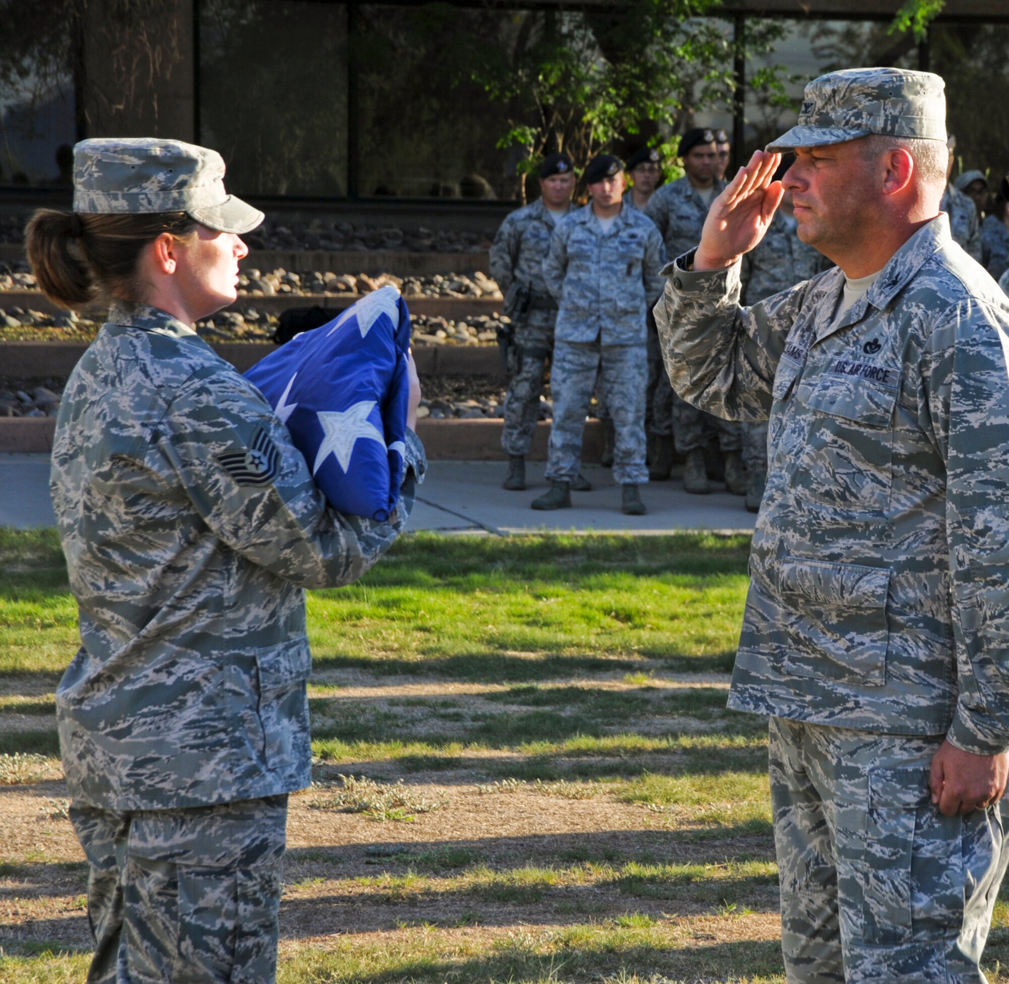 U.S. Air Force Col. Greg Williams, 355th Mission Support Group commander, salutes the American Flag during a 355th MSG retreat at Davis-Monthan Air Force Base, Ariz., Sept. 26, 2013. Traditionally, when the flag passes in a procession, or when it is hoisted or lowered, all military personnel should face the flag and render the proper salute. (U.S. Air Force photo by Senior Airman Justin Veazie/Released)