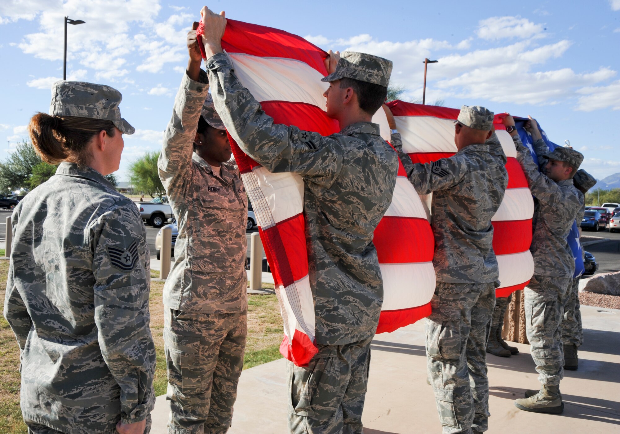 U.S. Air Force Airmen fold the American Flag during a 355th Mission Support Group retreat at Davis-Monthan Air Force Base, Ariz., Sept. 26, 2013. The Flag is carefully folded into the shape of a tri-cornered hat, emblematic of the hats worn by colonial soldiers during the war for Independence. (U.S. Air Force photo by Senior Airman Justin Veazie/Released)