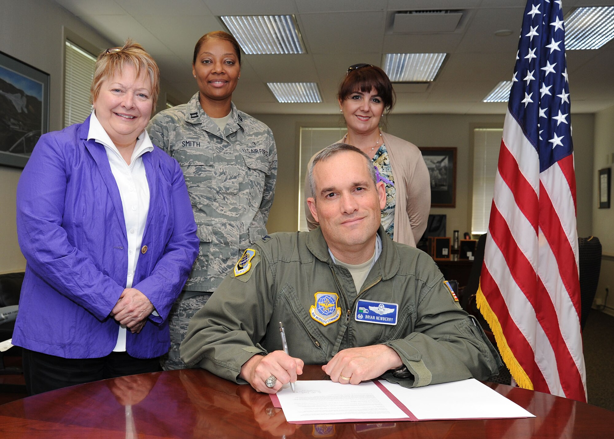 Col. Brian Newberry, 92nd Air Refueling Wing commander, signs the proclamation for Domestic Violence Awareness Month with the domestic abuse advocates and family advocacy officer at Fairchild Air Force Base, Wash., Oct. 1, 2013. Team Fairchild will be raising awareness about domestic violence for the whole month of October. (U.S. Air Force photo by Airman 1st Class Janelle Patiño/Released)
