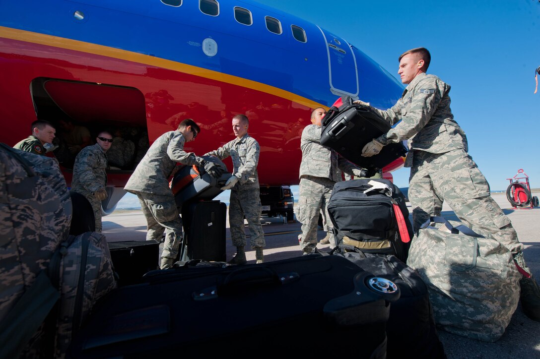 Airmen from the 34th Aircraft Maintenance Unit and 37th Bomb Squadron load luggage into a commercial aircraft destined for Nellis Air Force Base, Nev., prior to departure at Ellsworth AFB, S.D., Sept. 26, 2013. Approximately 140 Airmen and B-1 bombers from Ellsworth will be participating in Green Flag at Nellis, an exercise designed to test the base’s ability to survive and operate in a wartime environment. (U.S. Air Force photo by Senior Airman Zachary Hada/Released)