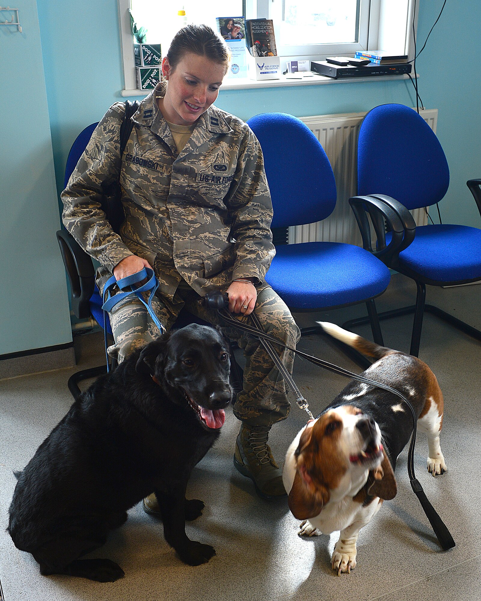 Capt. Emily Grabowski, 48th Fighter Wing chief of public affairs and her two dogs, Midnight (left) and Baxter, wait to be seen for their initial check-up appointment at Royal Air Force Feltwell Veterinary Clinic, England, Aug. 28, 2013. The Veterinary Clinic provides medical care to family pets of all U.S. forces in the United Kingdom, including care to military working dogs. (U.S. Air Force photo by Staff Sgt. Stephanie Mancha/Released)