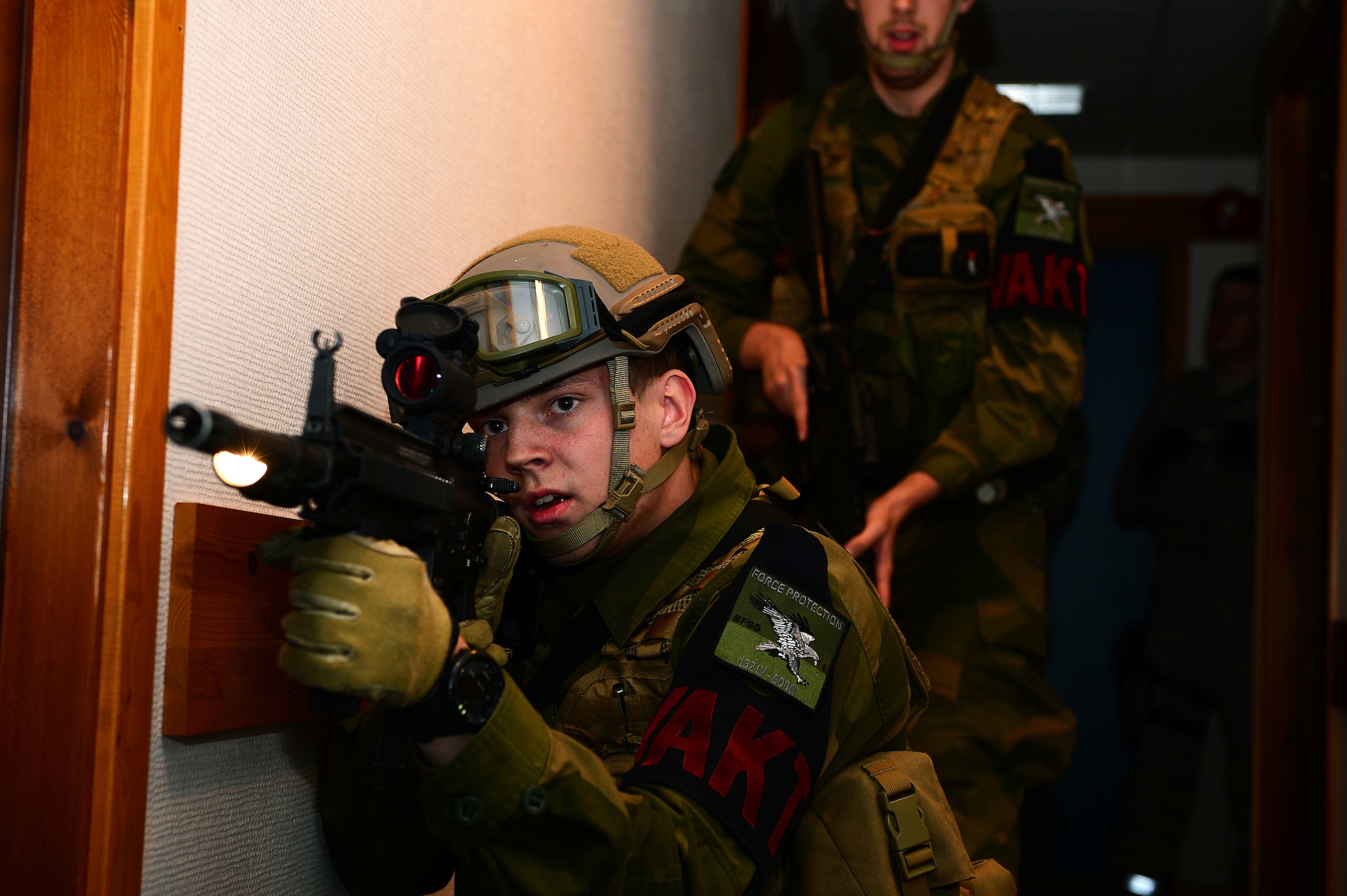 Royal Norwegian Air Force Pvt. Andreas Teigen scans the area for hostile assailants during a close quarters combat exercise on Bodø Main Air Station, Norway Sept. 26, 2013. Airmen from the 48th Security Forces Squadron teamed with the Norwegian Force Protection Office and Finnish Military Police to conduct the training on the final day of the Arctic Challenge Exercise 2013.  ACE-13 was a combined exercise with NATO and regional allies, which promoted continued interoperability between the U.S., Norway, Sweden, Finland the U.K. and NATO. (U.S. Air Force photo by Master Sgt. Lee Osberry/Released)