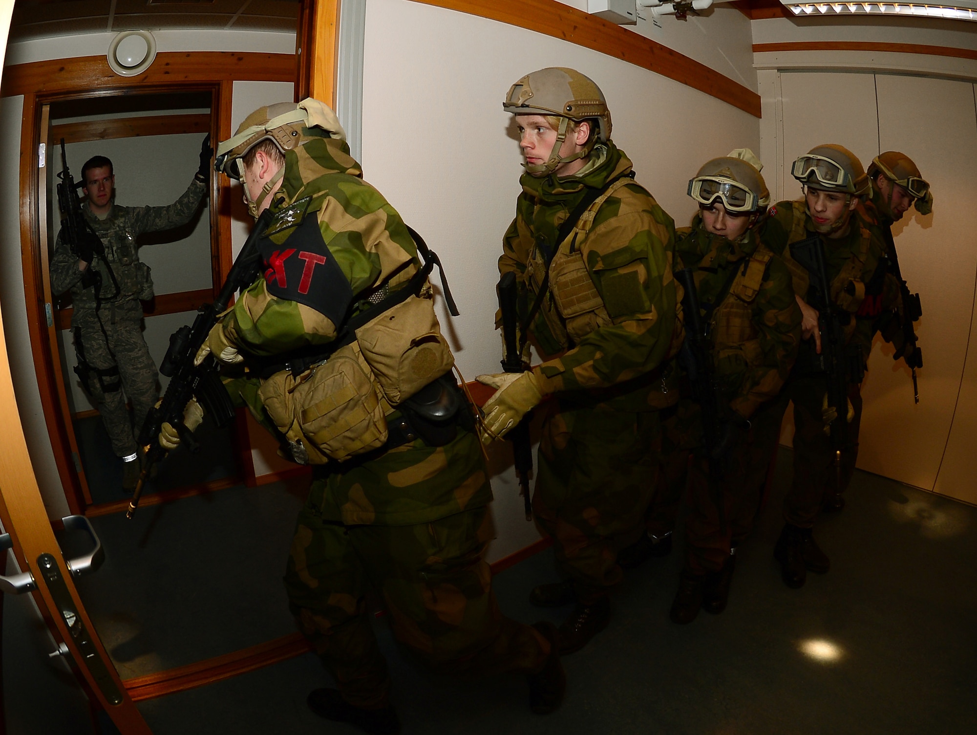 Royal Norwegian Air Force force protection members maneuver to secure the next area during a close quarters combat exercise on Bodø Main Air Station, Norway Sept. 26, 2013. Airmen from the 48th Security Forces Squadron teamed with the Norwegian Force Protection Office and Finnish Military Police to conduct the training on the final day of the Arctic Challenge Exercise 2013.  ACE-13 was a combined exercise with NATO and regional allies, which promoted continued interoperability between the U.S., Norway, Sweden, Finland the U.K. and NATO. (U.S. Air Force photo by Master Sgt. Lee Osberry/Released)