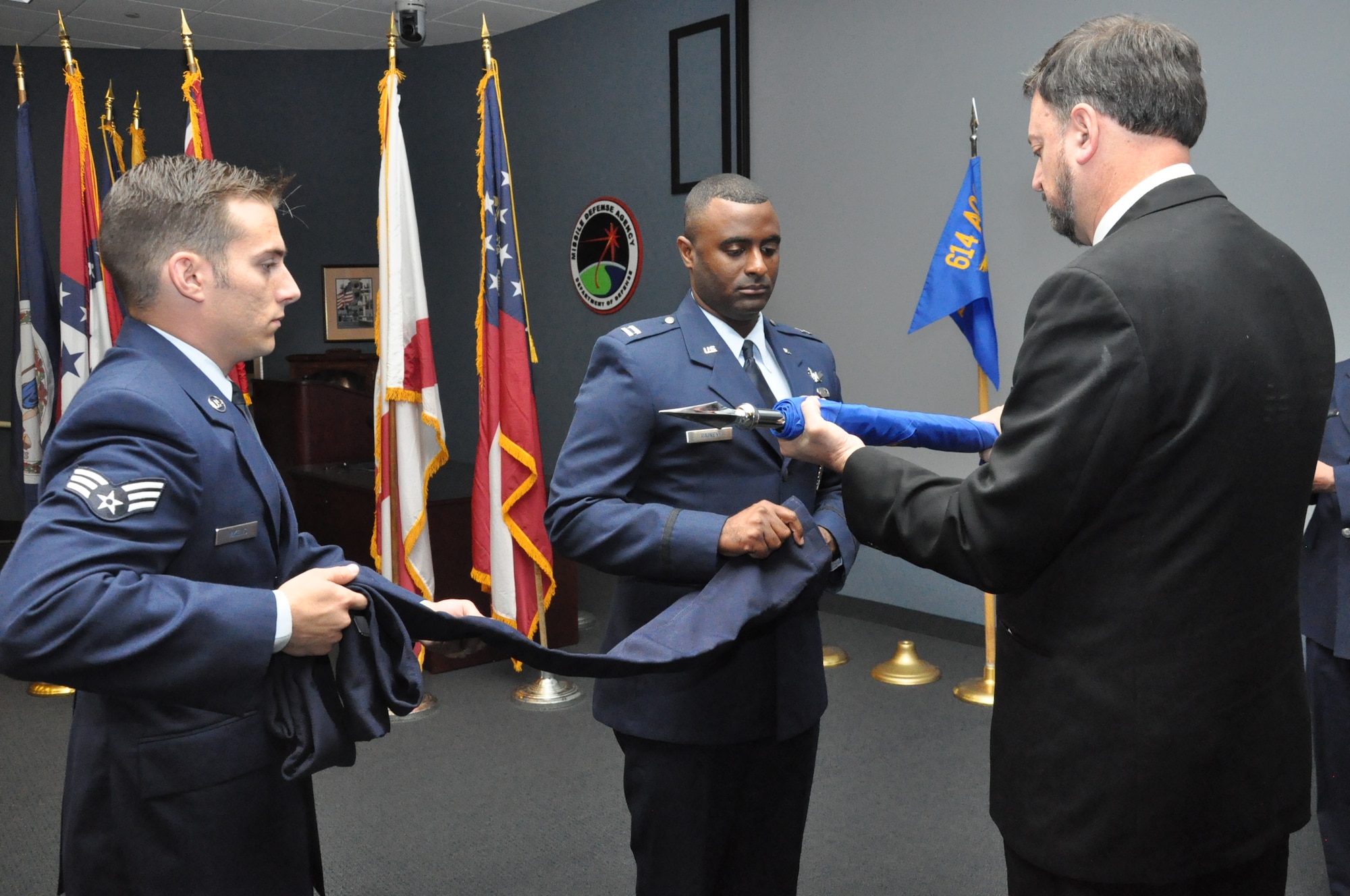 NAVAL SUPPORT FACILITY DAHLGREN, Va. – Capt. Roland Rainey, commander, 614th Air and Space Operations Center, Det. 1, performs a flag casing ceremony during the Air Force Space Surveillance System and 20th Space Control Squadron, Det. 1 closing ceremony Oct. 1. Roland was assisted in the ceremony by current 20th SPCS, Det. 1 members including Kenneth St. Clair, Senior Airman Nicholas Mikelis, and Tech. Sgt. John McIntyre (not pictured). The 20th SPCS, Det. 1 manpower and resources have been realigned under the 614th AOC, Det. 1. (Courtesy photo)