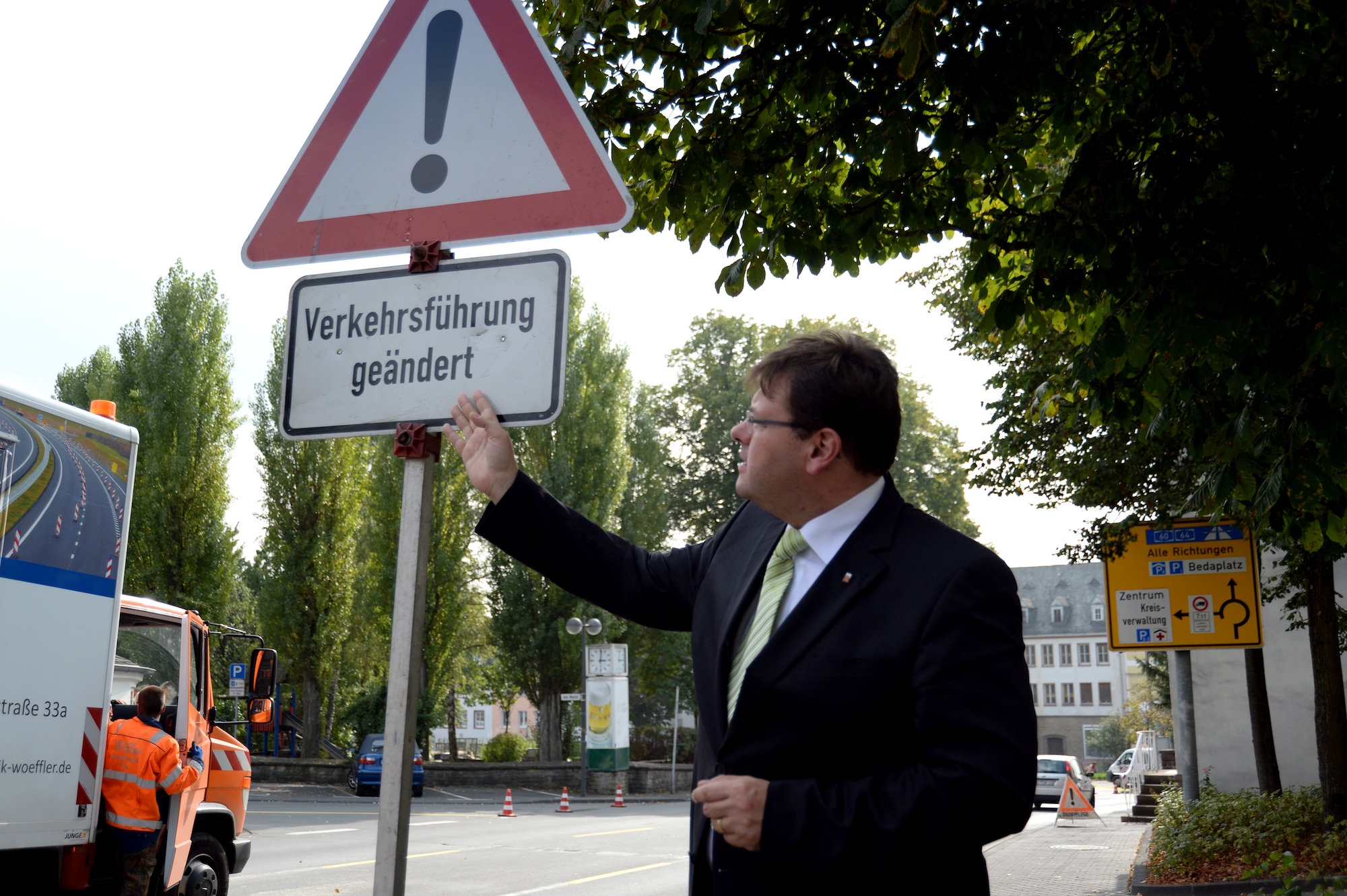 BITBURG, Germany --- Joachim Kandels, mayor of Bitburg, points to a traffic warning sign at a street junction near city hall Sept. 26, 2013. The sign, indicating a changed traffic flow, is part of the city’s new inner-city traffic circle initiative. (U.S. Air Force photo by Senior Airman Joe W. McFadden / Released)