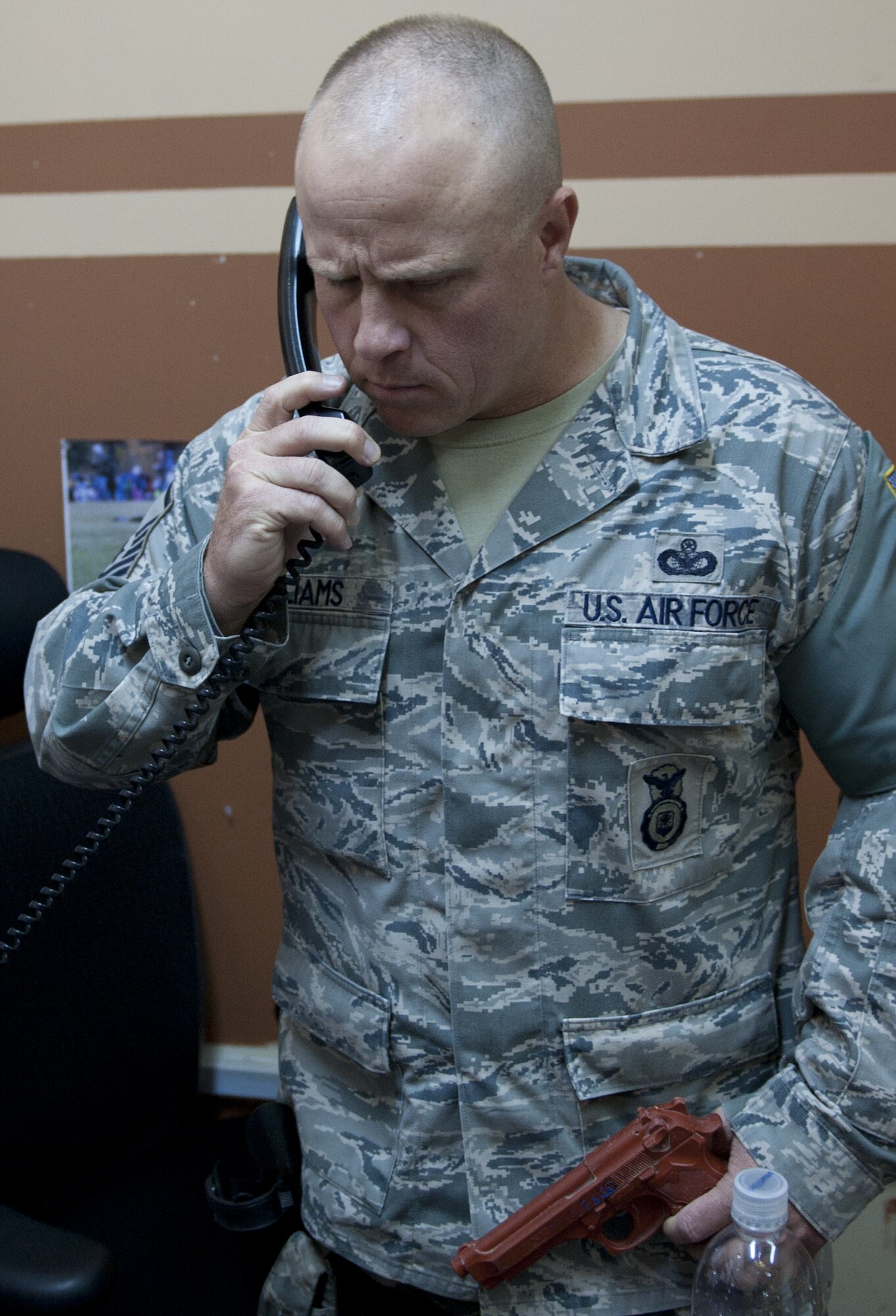 U.S. Air Force Master Sgt. Kyle Williams, 380th Expeditionary Security Forces Squadron logistics superintendant, talks to a negotiator from the location he was holding exercise hostages at an undisclosed location in Southwest Asia Sept. 26, 2013. Williams played the active-shooter during the exercise. He calls Lehighton, Penn., home. (U.S. Air Force photo by Staff Sgt. Jacob Morgan) 