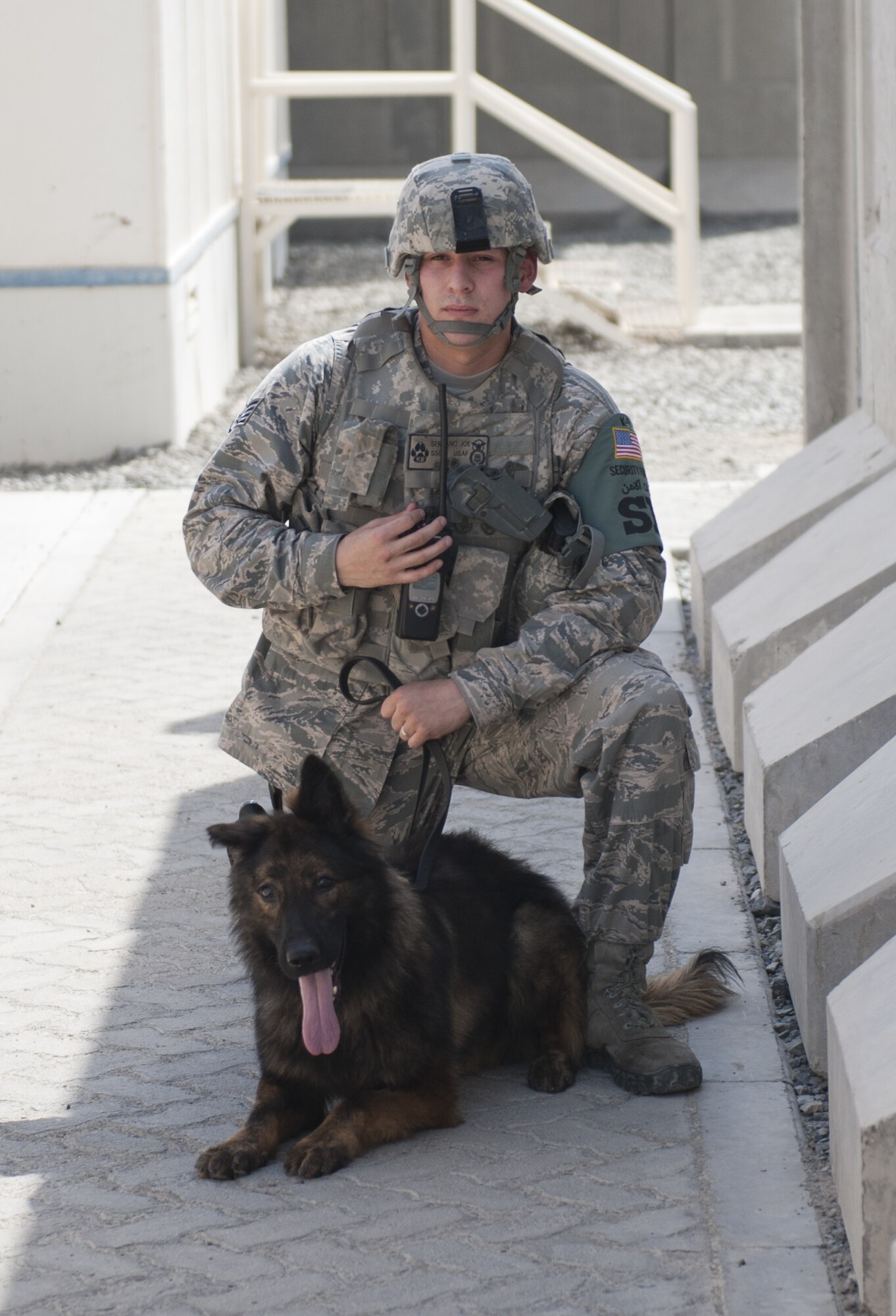 U.S. Air Force Staff Sgt. Joseph Serrano, 380th Expeditionary Security Forces Squadron K-9 handler and his military working dog, Gandi, stand ready during an active-shooter exercise at an undisclosed location in Southwest Asia Sept. 26, 2013. The K-9 team responded immediately after the exercise active-shooter stopped in the building to hold hostages. Serrano calls Canyon Country, Calif., home and is deployed from Royal Air Force Mildenhall, England. (U.S. Air Force photo by Staff Sgt. Jacob Morgan)