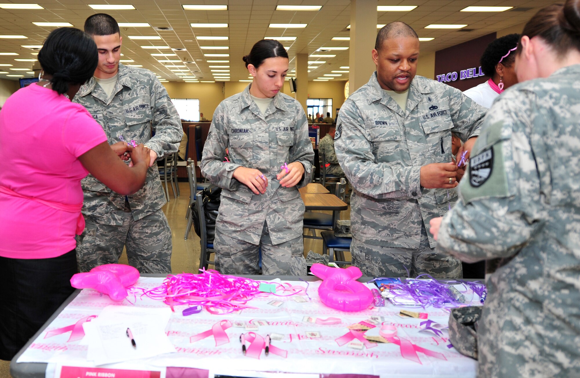 Members of Team Osan man an information table as part of Breast Cancer and Domestic Violence Awareness Month at Osan Air Base, Republic of Korea, Oct. 1, 2013. Several events will be held throughout October, including a candlelight vigil and a 5K run, to promote awareness of and inform the base populace about these issues. (U.S. Air Force photo/Airman 1st Class Ashley J. Thum)