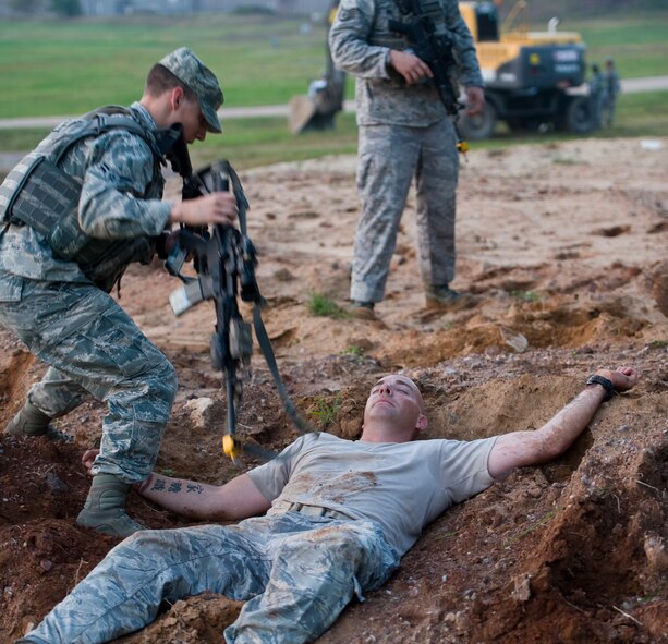 Staff Sgt. Dennis Sherrill, 8th Security Forces Squadron instructor has his weapon removed after being “killed” during a simulated attack at Kunsan Air Base, Republic of Korea, Sept. 30, 2013. Sherrill and other SFS instructors tested Airmen on their ability to react accordingly under stress during exercise Beverly Midnight 13-4. (U.S. Air Force photo by Senior Airman Armando A. Schwier-Morales/ Released)