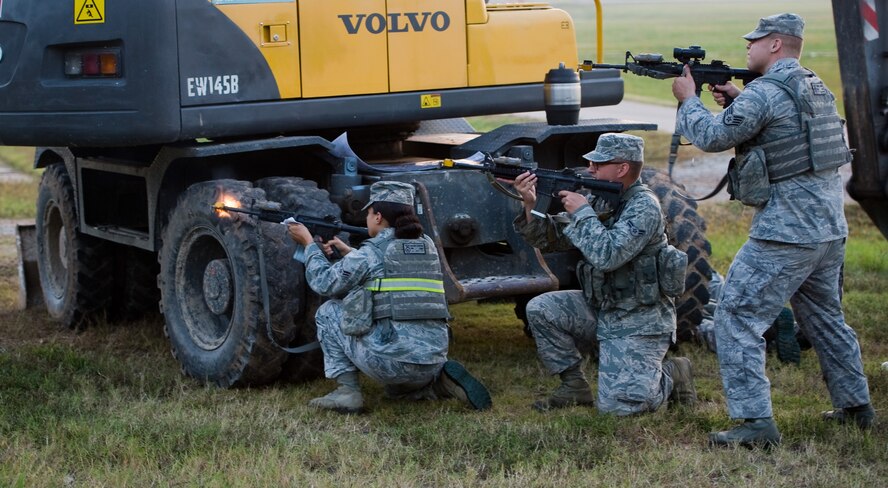 Airman 1st Class Kolina Burton, 8th Security Forces Squadron team member, left, Airman 1st Class Victor Ristau, 8th SFS team member, middle, and Staff Sgt. Joshua Denny, 8th SFS team lead, right, return fire with simulated rounds against training instructors posing as opposition forces at Kunsan Air Base, Republic of Korea, Sept. 30, 2013. Exercise Beverly Midnight 13-4 kicked off for the 8th SFS with a variety of skills tests mixed in with opposition forces threats. (U.S. Air Force photo by Senior Airman Armando A. Schwier-Morales/ Released)