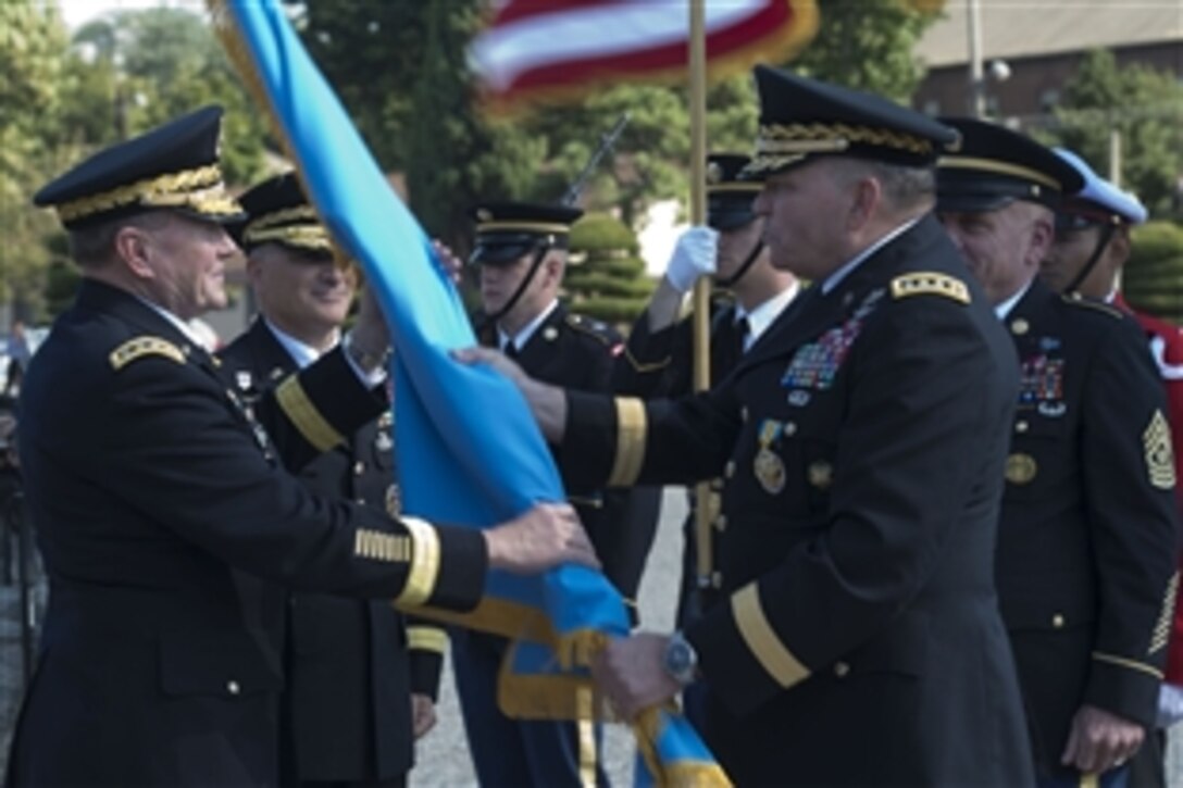 U.S. Army Gen. Martin E. Dempsey, left, chairman of the Joint Chiefs of Staff, receives the battle colors from U.S. Army Gen. James D. Thurman during the U.S. Forces Korea change-of-command ceremony in Seoul, South Korea, Oct. 2, 2013. Thurman passed command to U.S. Army Gen. Curtis M. Scaparrotti.