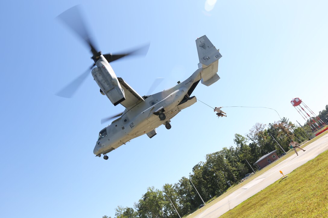 A Marine Multipurpose Canine (MPC) handler with Marine Corps Special Operations Command, and his dog fast rope off a MV-22 Osprey while conducting MPC Helicopter Rope Suspension Training Course aboard Camp Lejeune, N.C., Sept. 19, 2013. MARSOC MPC program is developing a standard operating procedures, while also partaking in the training to build the program.   (U.S. Marine Corps photo by Sgt. Anthony Carter/Released)