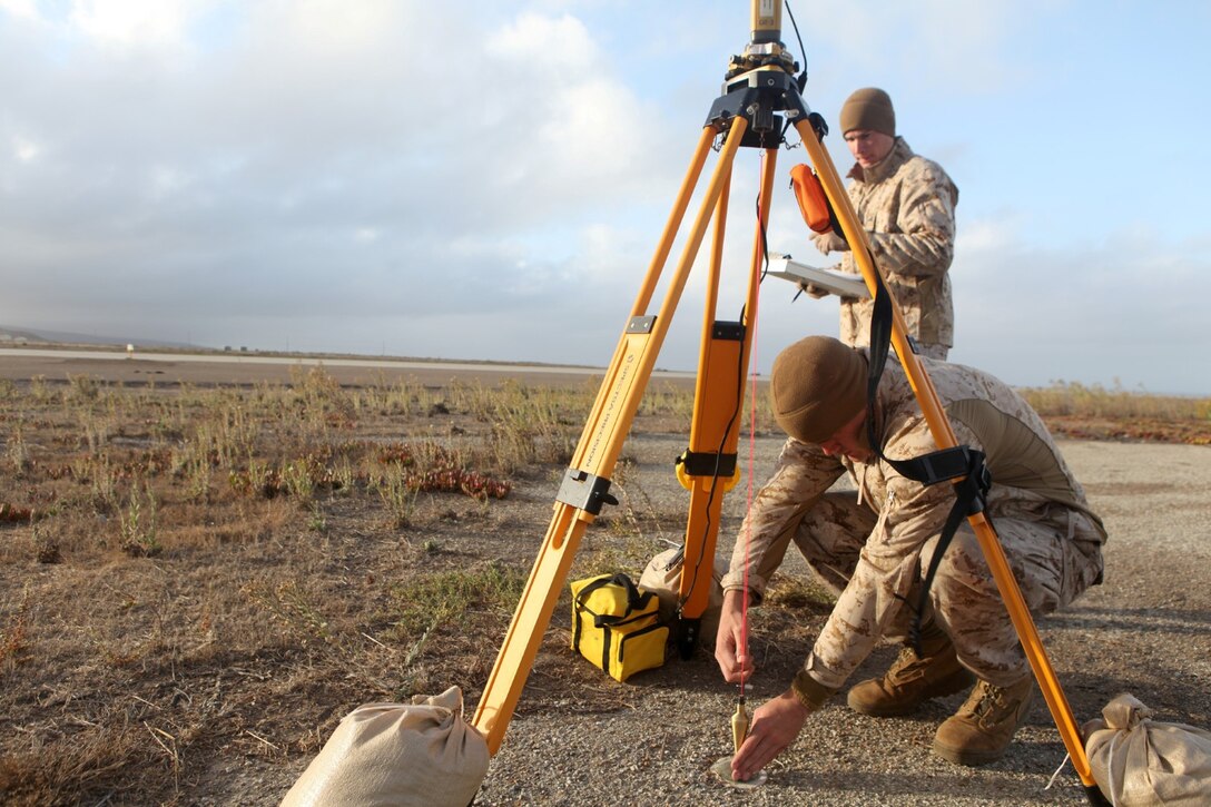 Marines with Geodetic Survey Team, 1st Intelligence Battalion, check a GPS for accuracy during a survey of the Naval Auxiliary Landing Field at San Clemente Island, Calif., Sept. 25, 2013. The GPS is used to find the exact elevation of the airfield. The data collected from these GPS points are used as a reference point to find elevations of obstructions in any possible flight path near the landing zone.