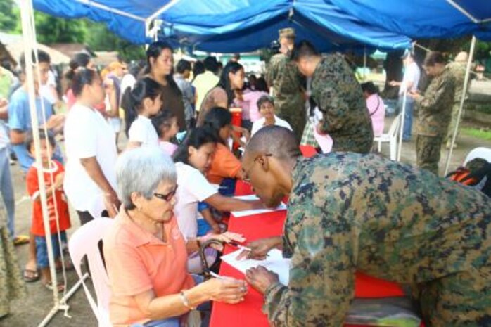 Petty Officer 2nd Class Stetson D. Thomas helps a local community member fill out her registration form Sept. 26 during a cooperative health engagement at Bigaa Elementary School, Legazpi City, Albay, Republic of the Philippines. Thomas is participating in Amphibious Landing Exercise 2014, a Philippine-U.S. exercise designed to improve interoperability, increase readiness, and enhance the ability for a bilateral force to respond to natural disasters or other regional contingencies. Thomas is a hospital corpsman with Combat Logistics Regiment 37, 3rd Marine Logistics Group, III Marine Expeditionary Force.