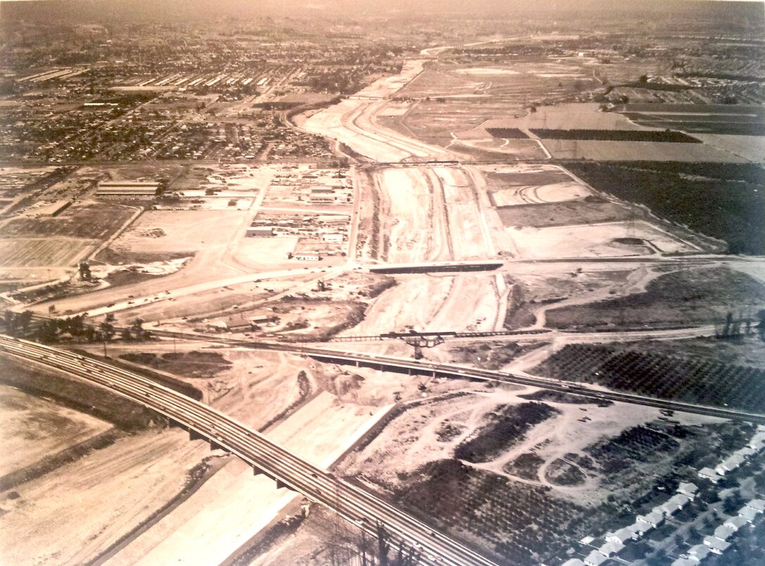 View looking upstream from the lower limits of the channel showing partially excavated and graded channel.  Santa Ana Freeway is in the foreground. 