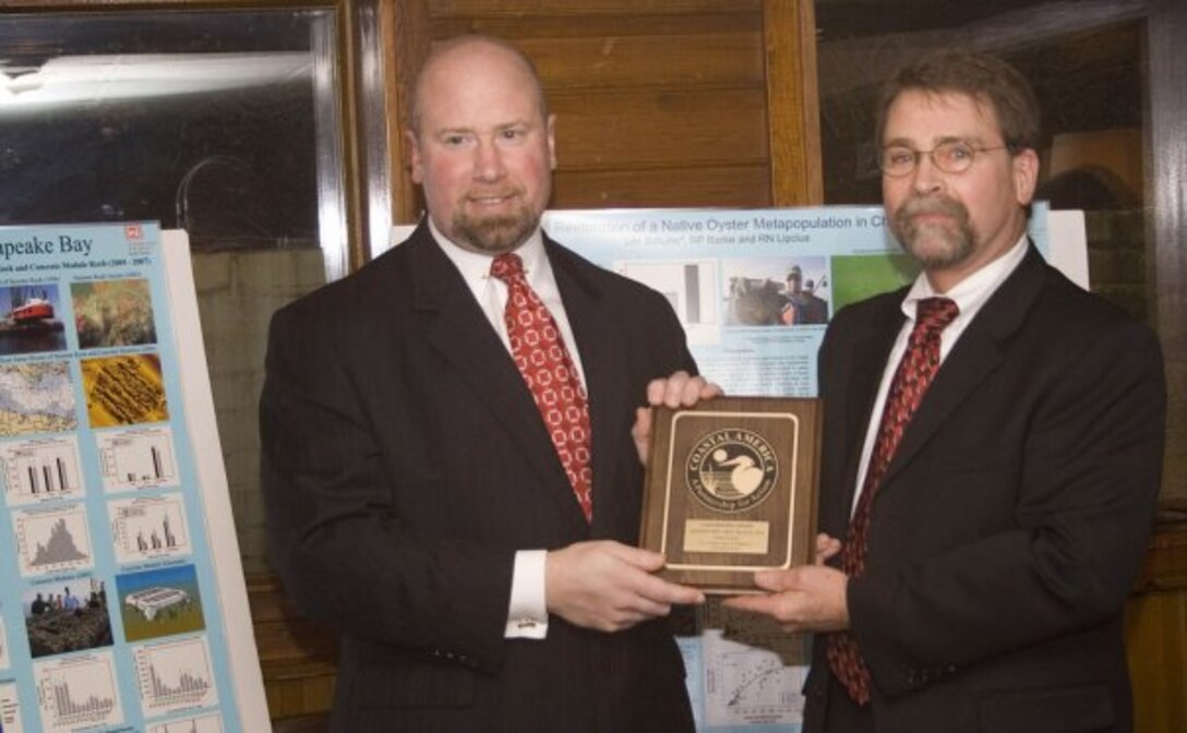 Oceanographer David Schulte (left) from the U.S. Army Corps of Engineers, Norfolk District, accepts the Coastal America plaque from Doug Lamont, assistant secretary of the Army (project planning and review), on behalf of the Corps’ collaborative efforts in oyster restoration in the Lynnhaven River. Partners in the ongoing initiative include the City of Virginia Beach, Lynnhaven River Now, Virginia Institute of Marine Science and the Virginia Marine Resources Commission.