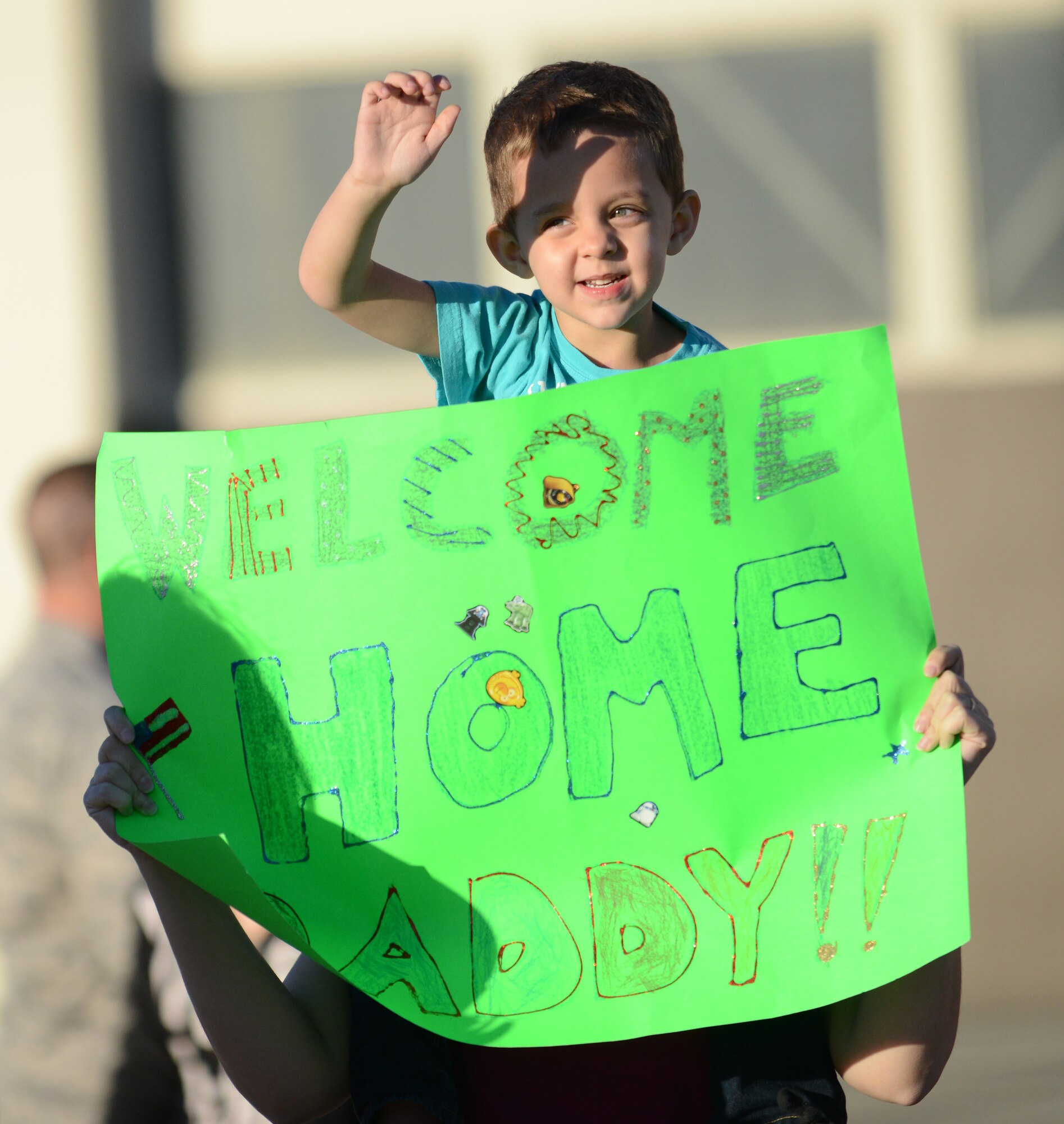 A small boy waves to his father Oct. 3, 2013, at Mountain Home Air Force Base, Idaho. More than 150 Airmen from the 366th Maintenance Group and 389th Fighter Squadron returned after six-months deployed to Southwest Asia in support of Operation Enduring Freedom. (U.S. Air Force photo by Senior Airman Benjamin Sutton/Released)  