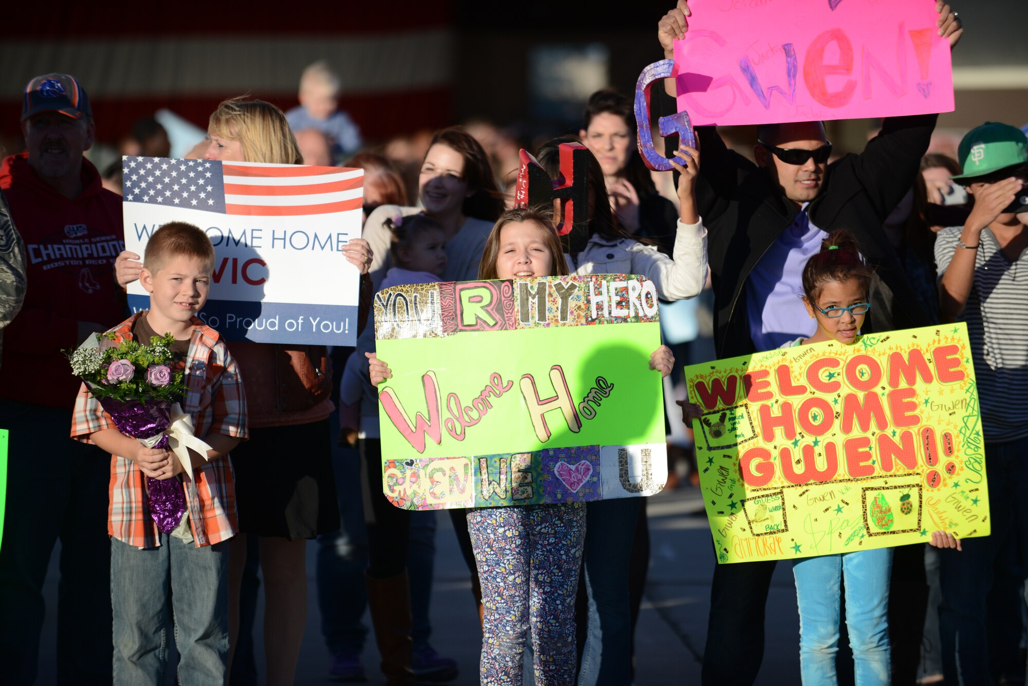 Family members wave signs while waiting for their loved-ones on the flight line Oct. 3, 2013, at Mountain Home Air Force Base, Idaho. Airmen from the 366th Maintenance Group and 389th Fighter Squadron returned from a six-month deployment to Southwest Asia. (U.S. Air Force photo by Senior Airman Benjamin Sutton/Released)