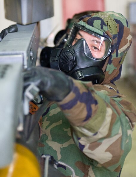 Staff Sgt. Trebor Lindstamer, 8th Aircraft Maintenance Squadron load crew chief, ensures a missle is connected during an exercise at Kunsan Air Base, Republic of Korea, Oct. 2, 2013. During exercise Beverly Midnight 13-4 Airmen from the 8th AMXS trained to continue the mission under a simulated chemical and biological attack. (U.S. Air Force photo by Senior Airman Armando A. Schwier-Morales/ Released)