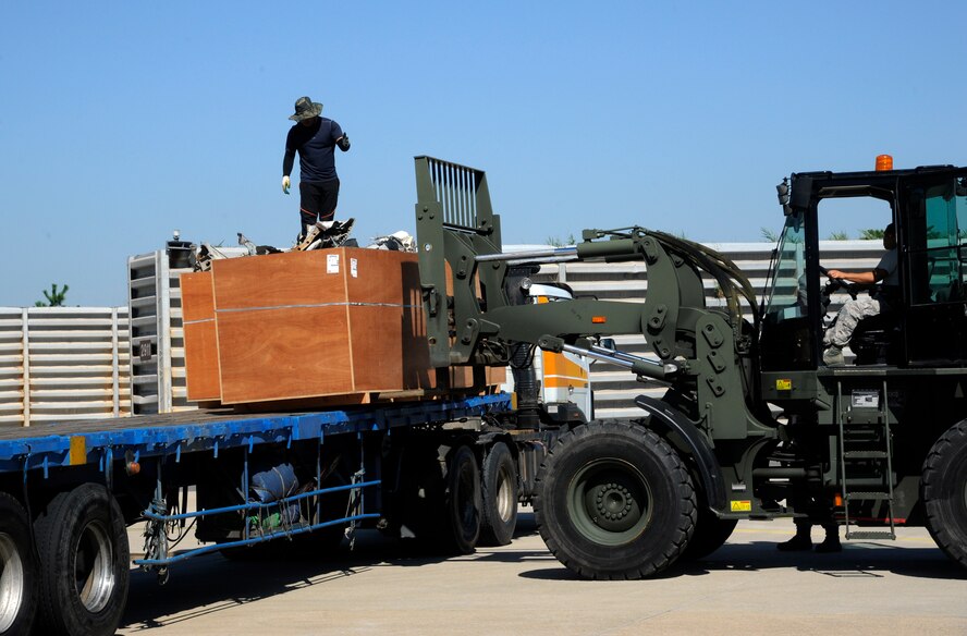 Airmen from the 8th Logistic Readiness Squadron pick up a pallet of cut up jet parts at Kunsan Air Base, Republic of Korea, Sept. 4, 2013. After months of preparation Airmen from the 8th LRS and 8th Maintenance Squadron helped ship the crashed F-16 Fighting Falcon on flatbed trucks bound for the U.S. (U.S. Air Force photo by Staff Sgt. Jessica Haas/ Released)