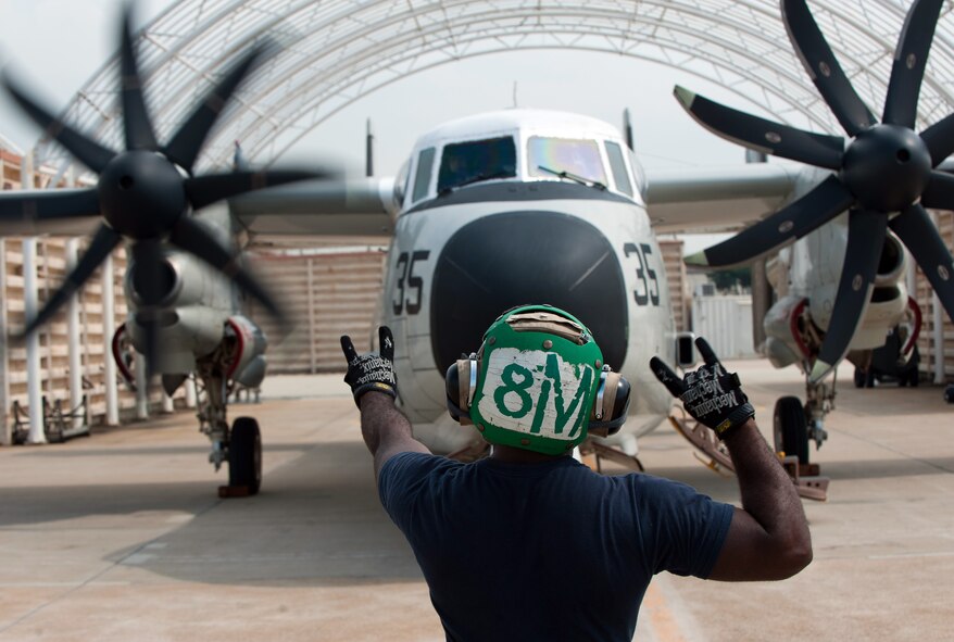 Aviation Structural Mechanic 3rd Class Alex Foncham, Fleet Logistics Support Squadron (VRC) 30, Detachment 5, signals to the pilot while preparing a C-2A Greyhound for takeoff at Kunsan Air Base, Republic of Korea, Oct. 1, 2013. The “Providers” delivered mail and cargo to the USS George Washington (CVN 73) off the coast of the Republic of Korea. (U.S. Air Force photo by Senior Airman Clayton Lenhardt/Released)