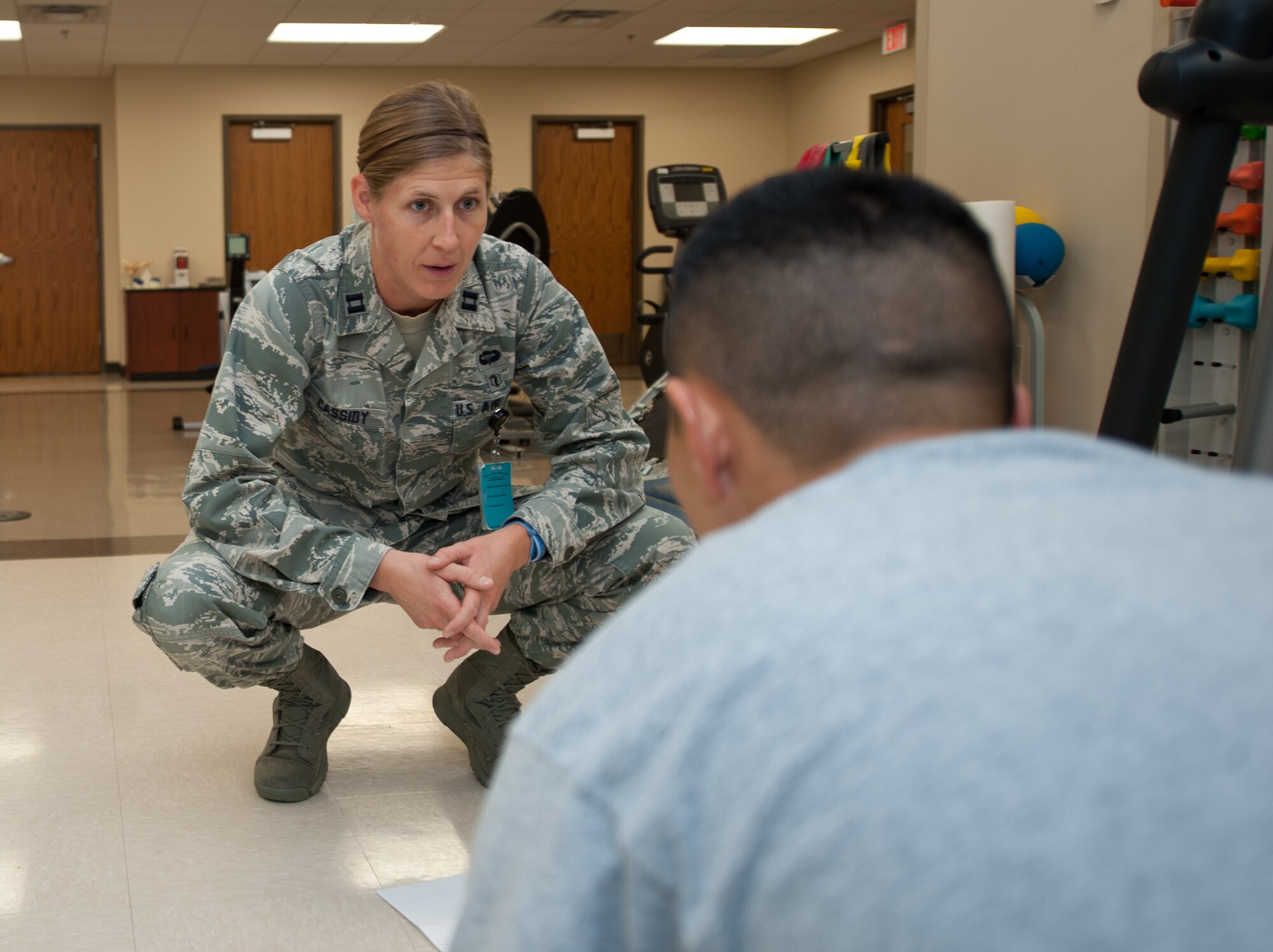 Capt. Patricia Cassidy, 28th Medical Operations Squadron physical therapy officer in charge, watches as Capt. Chad Nishizuka, 34th Bomb Squadron chief of weapons and tactics, performs push-ups and arm walks during a physical therapy appointment at Ellsworth Air Force Base, S.D., Oct. 2, 2013. In an effort to reduce recovery time and pain during therapy, Cassidy works with her patients to ensure they are performing exercises safely and correctly. (U.S. Air Force photo by Airman 1st Class Alystria Maurer/Released)