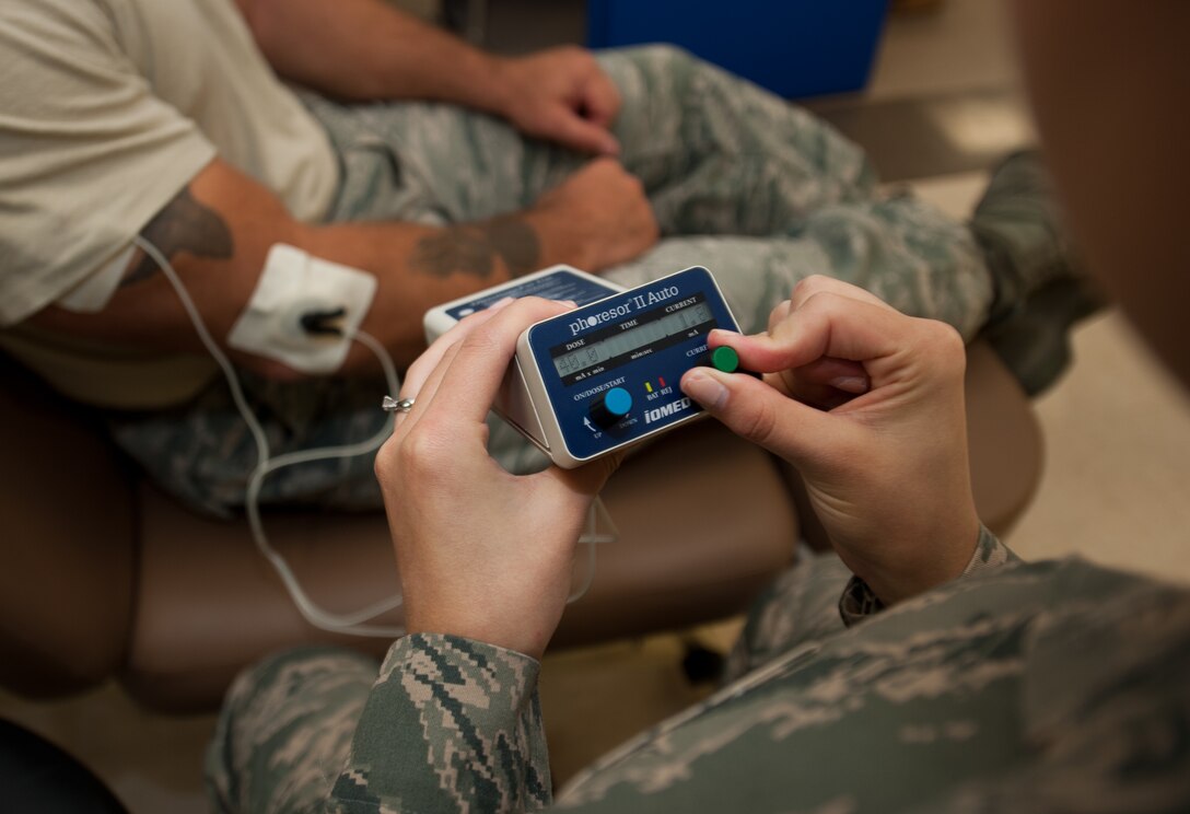 Senior Airman Haylley Turney, 28th Medical Operations Squadron physical therapy technician, raises the amount of electricity being applied to the electro pad on Master Sgt. Andrew Bousley, 28th Munitions Squadron line delivery section chief, during a physical therapy appointment at Ellsworth Air Force Base, S.D., Oct. 2, 2013. Turney is able to control the pace at which the medication is given to injured muscles by adjusting the amount of electricity that is being delivered to the affected area. (U.S. Air Force photo by Airman 1st Class Alystria Maurer/Released)