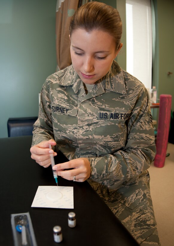 Senior Airman Haylley Turney, 28th Medical Operations Squadron physical therapy technician, applies an anti-inflammatory medication to an electro pad during a physical therapy appointment at Ellsworth Air Force Base, S.D., Oct. 2, 2013. Applying medicine to electro pads helps relive inflammation in inured muscles. (U.S. Air Force photo by Airman 1st Class Alystria Maurer/Released)