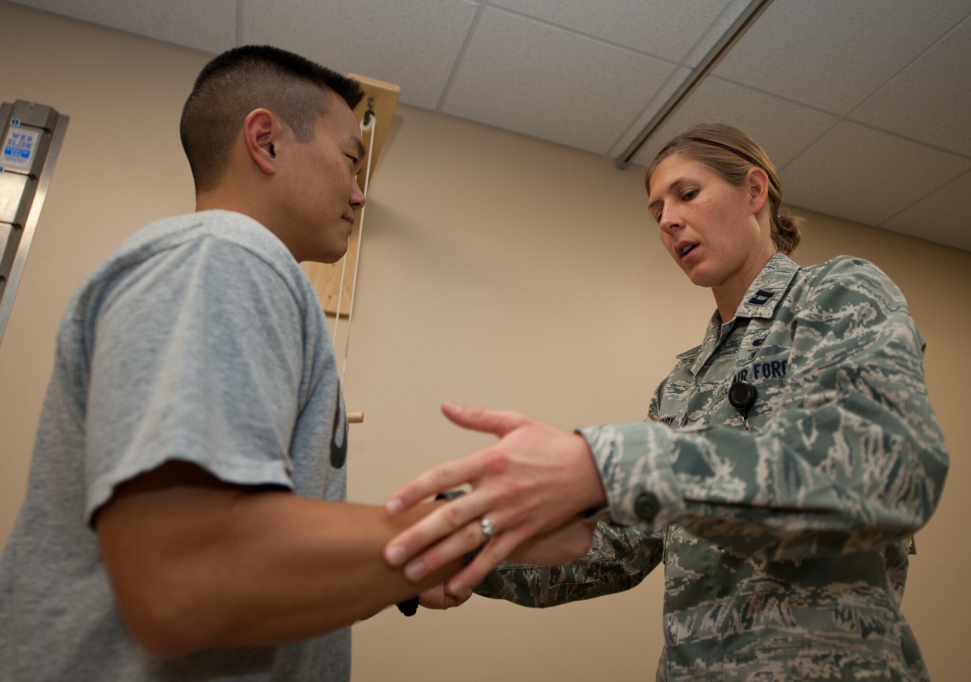 Capt. Patricia Cassidy, 28th Medical Operations Squadron physical therapy officer in charge, tests strength levels of Capt. Chad Nishizuka, 34th Bomb Squadron chief of weapons and tactics, during a physical therapy appointment at Ellsworth Air Force Base, S.D., Oct. 2, 2013. The 28th MDOS physical therapists provide patients with therapeutic treatments designed to relieve pain and restore normal muscle and joint functions. (U.S. Air Force photo by Airman 1st Class Alystria Maurer/Released)