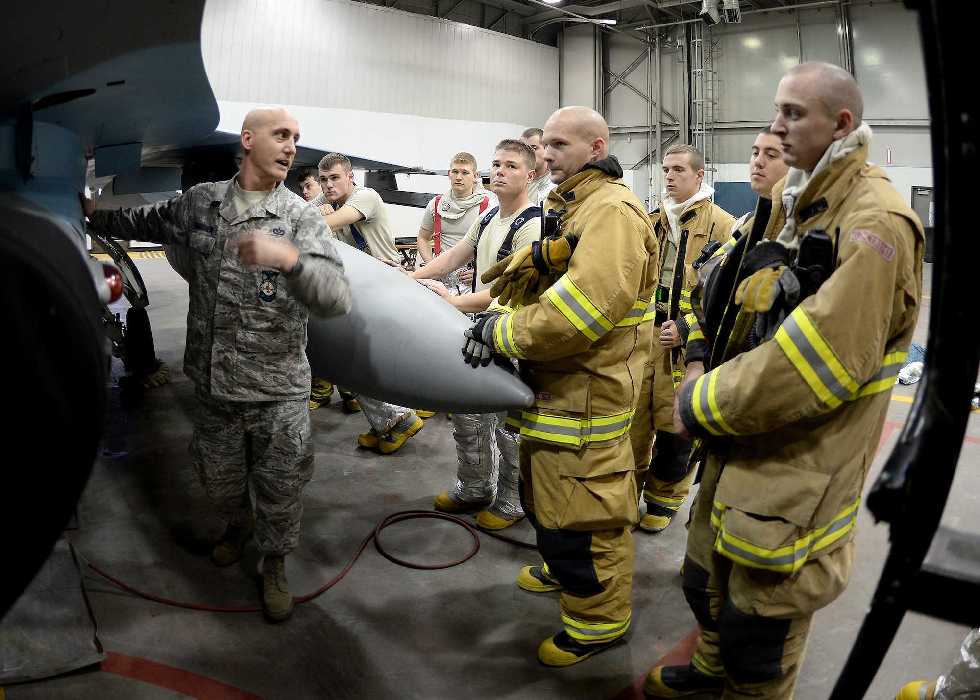 Tech. Sgt. Darnell Strausheim, 354th Civil Engineer Squadron station captain, gives detailed instructions on how to approach an F-16 Fighting Falcon when responding to a simulated unconscious pilot Sept. 19, 2013, Eielson Air Force Base, Alaska. Firefighters debrief and learn from each other’s mistakes after each training scenario. (U.S. Air Force photo by Senior Airman Shawn Nickel/Released)