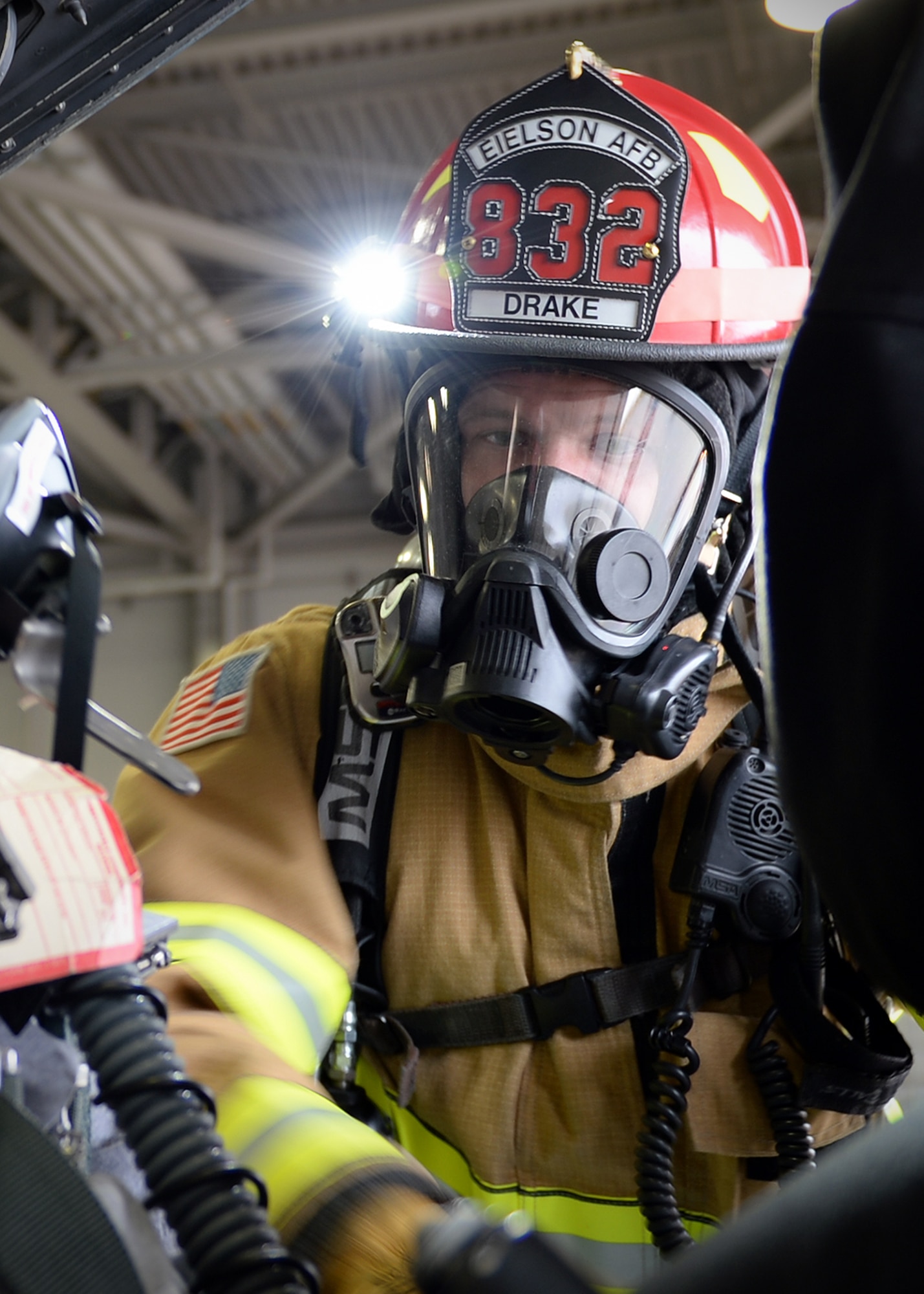 Staff Sgt. Alan Drake leans into the cockpit of an F-16 Fighting Falcon during training Sept. 19, 2013, Eielson Air Force Base, Alaska. Firefighters responded to a simulated unconscious pilot trapped in the aircraft. (U.S. Air Force photo by Senior Airman Shawn Nickel/Released)