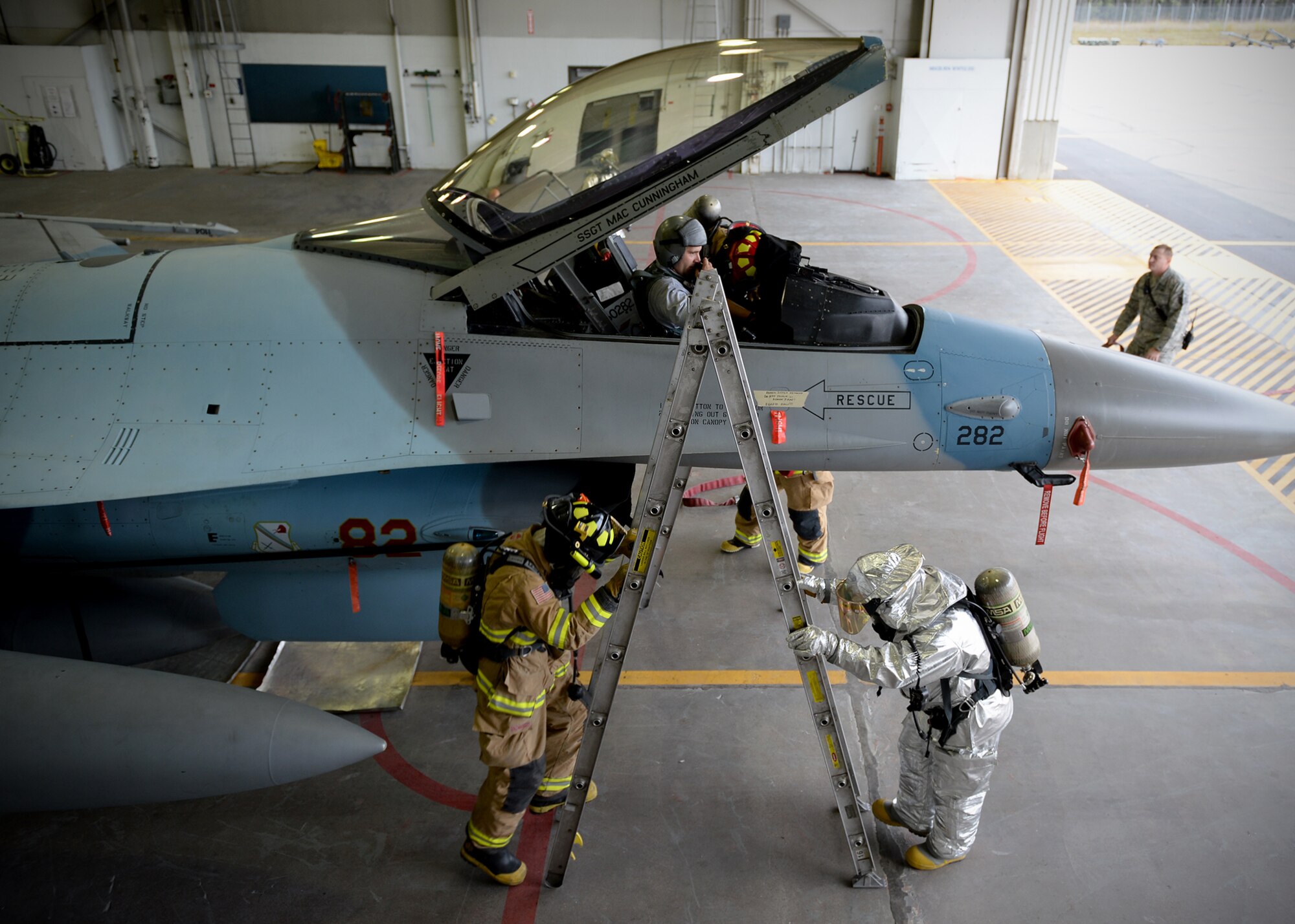 Airman 1st Class Matthew Barlow and Mr. Matthew Erickson, 354th Civil Engineer Squadron firefighters, work to rescue a simulated unconscious pilot from an F-16 Fighting Falcon during training Sept. 19, 2013, Eielson Air Force Base, Alaska. Teamwork is essential to every rescue ensuring the safety of victims and of emergency personnel. (U.S. Air Force photo by Senior Airman Shawn Nickel/Released)