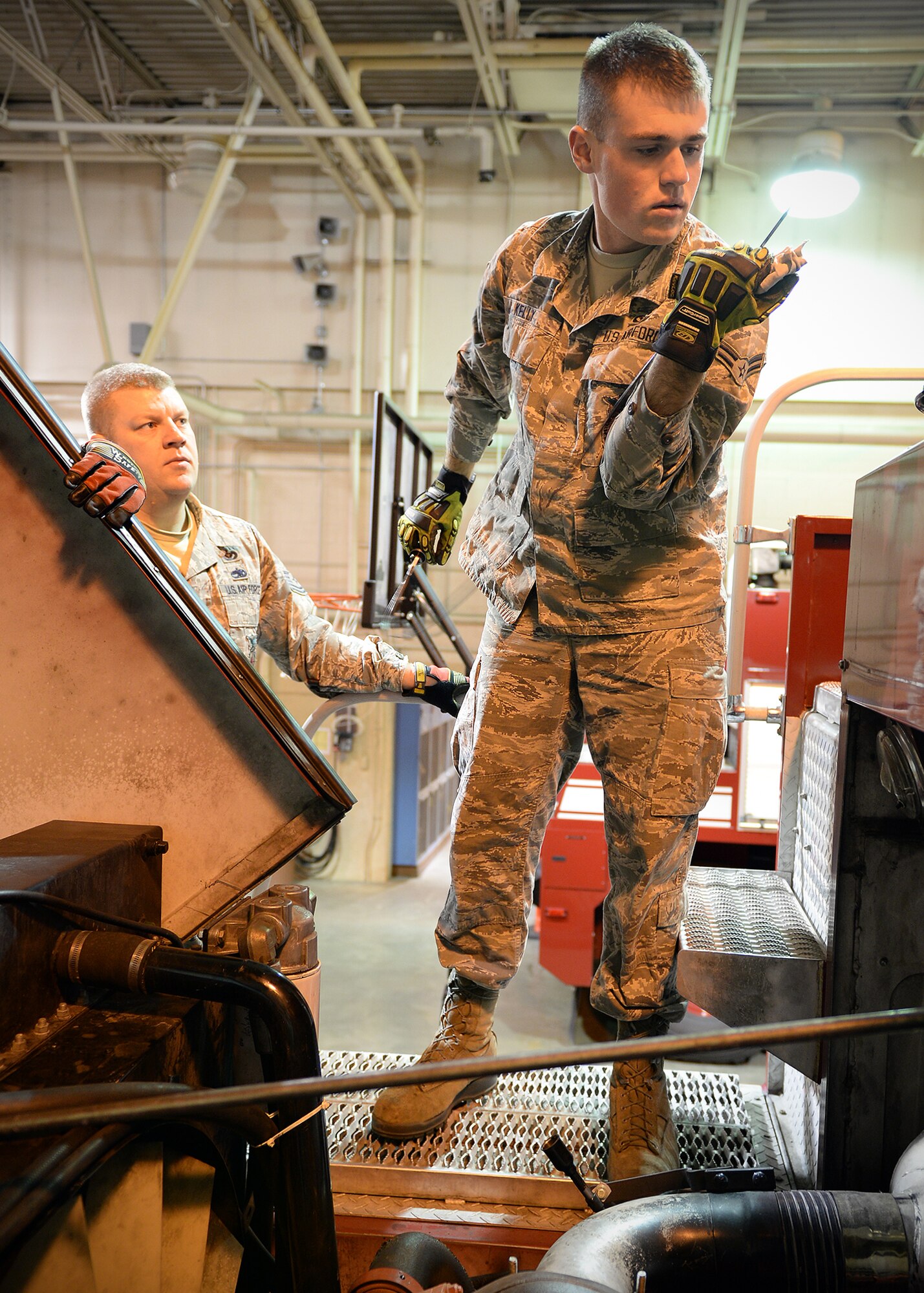 Airman 1st Class Matthew Kelly, 354th Civil Engineer Squadron firefighter, and Tech. Sgt. Jack Pyle, lead firefighter, check the engine fluids on a fire truck Sept. 19, 2013, Eielson Air Force Base, Alaska. Each junior firefighter must prove proficiency to maintain equipment and vehicles under the watch of a lead firefighter. (U.S. Air Force photo by Senior Airman Shawn Nickel/Released)

